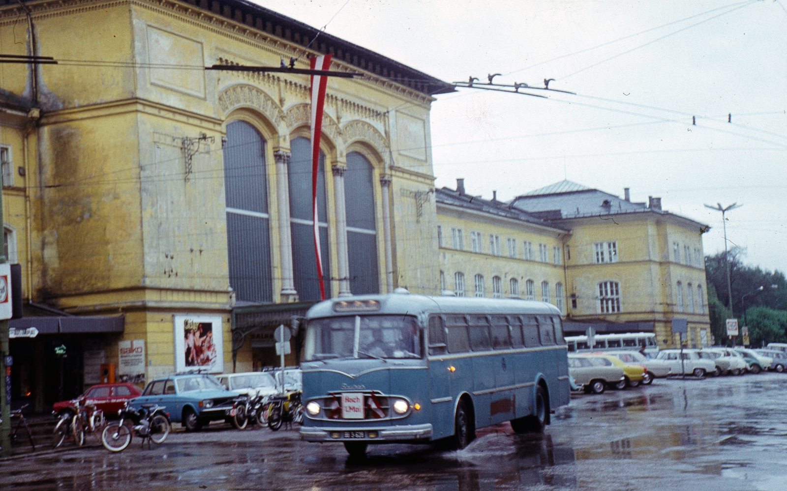 Austria, Salzburg, főpályaudvar., 1971, Kristek Pál, colorful, bus, flag, motorcycle, train station, automobile, rain, bicycle, Saurer brand, Fortepan #75564