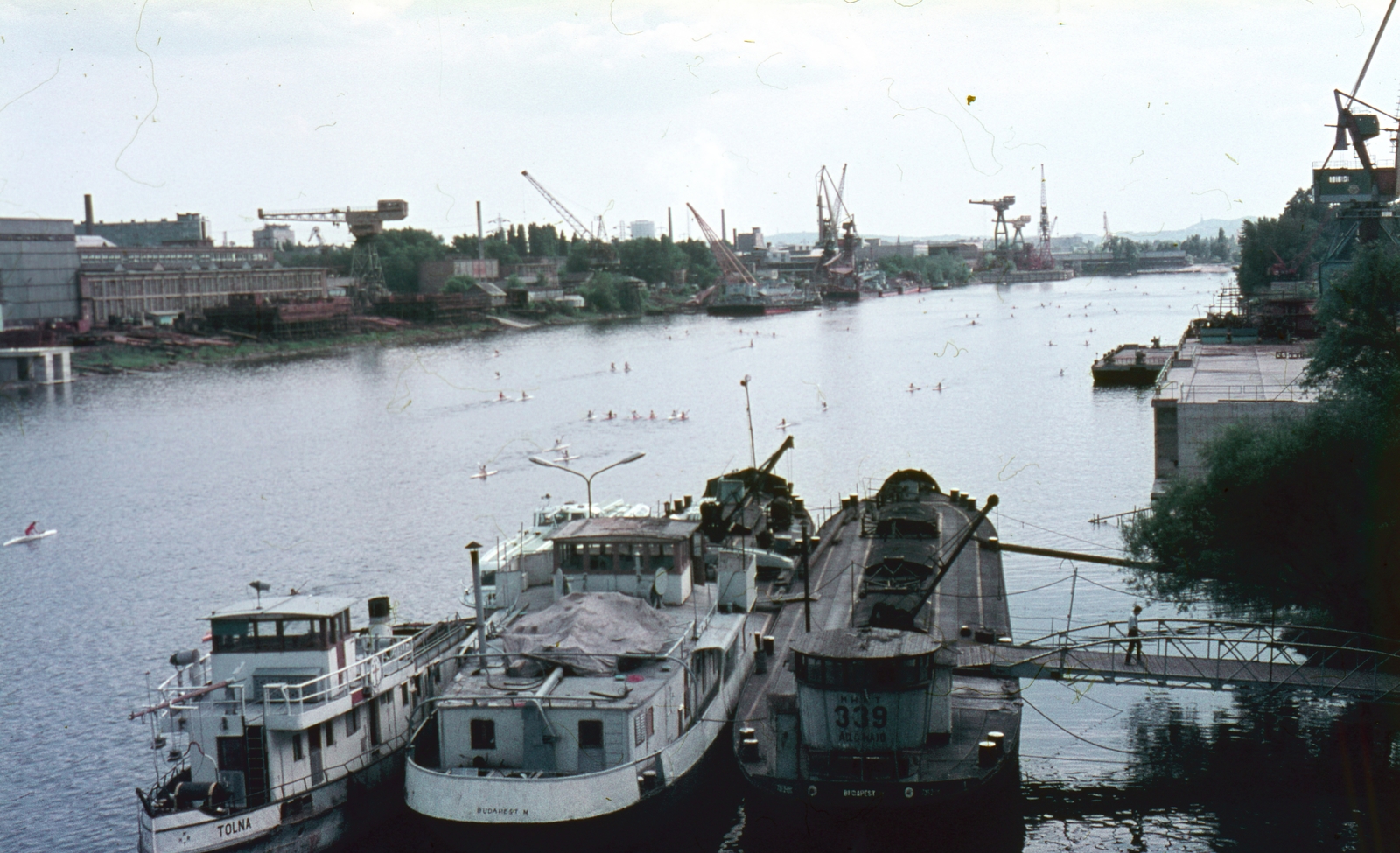 Hungary, Budapest XIII., Újpesti-öböl, háttérben az MHD Angyalföldi gyáregysége., 1986, Kristek Pál, ship, colorful, crane, barge, kayak, factory, dredge, Tolna/Rákos/S. T. 9. ship, Budapest, Fortepan #75636