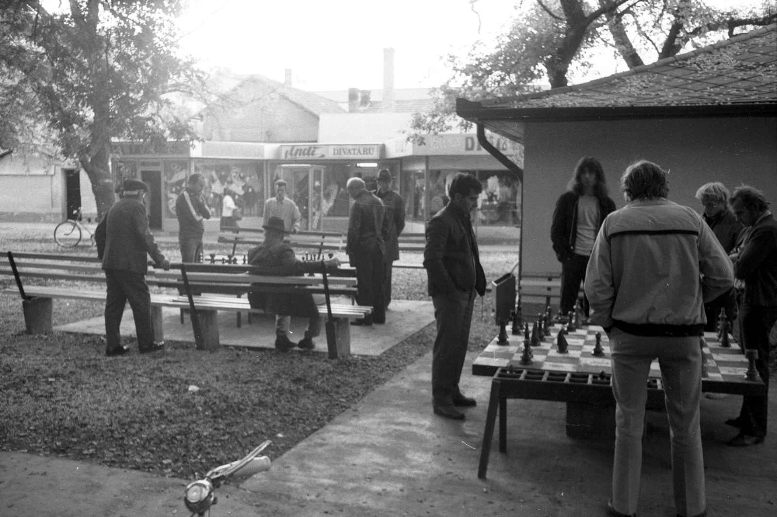 Hungary, Orosháza, Széchenyi tér., 1983, Jankó Attila, bicycle, chess, men, square, store display, bench, Fortepan #75690
