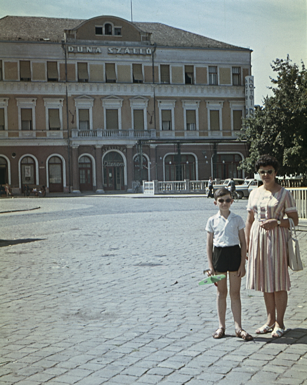 Hungary, Baja, Szentháromság (Béke) tér, szemben a Duna Hotel., 1968, Erky-Nagy Tibor, colorful, street view, hotel, shades, cobblestones, handbag, model plane, sandal, Fortepan #76728