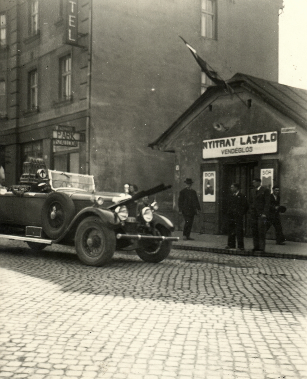 Szlovákia, Érsekújvár, Milan Rastislav Štefánik (ekkor Széchenyi) utca a Park Szálló előtt. A személygépkocsiban a Szent Jobb látható, 1939. április 30.-án., 1939, Klenner Aladár, felirat, utcakép, üzletportál, automobil, vendéglő, Fortepan #76801