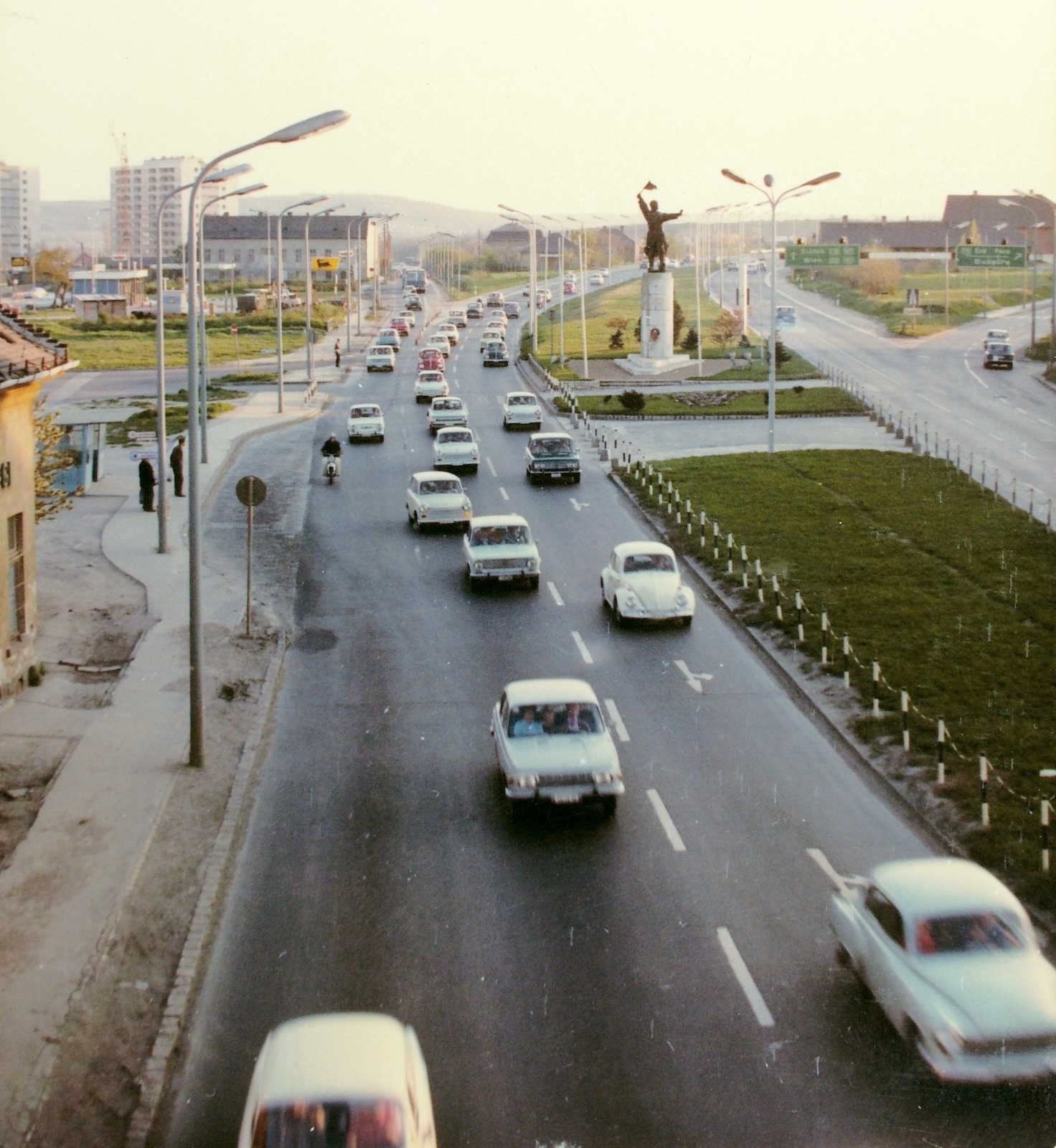 Hungary, Budapest XI., Budaörsi út. Szemben az Osztapenko szobor a Balatoni út és az M1-M7 közös szakaszának találkozásánál., 1976, Fortepan, transport, colorful, traffic, sculpture, construction, road signs, Volkswagen-brand, gas station, automobile, Volkswagen Beetle, Agip-brand, Ostapenko Ilya portrayal, Budapest, Fortepan #7801