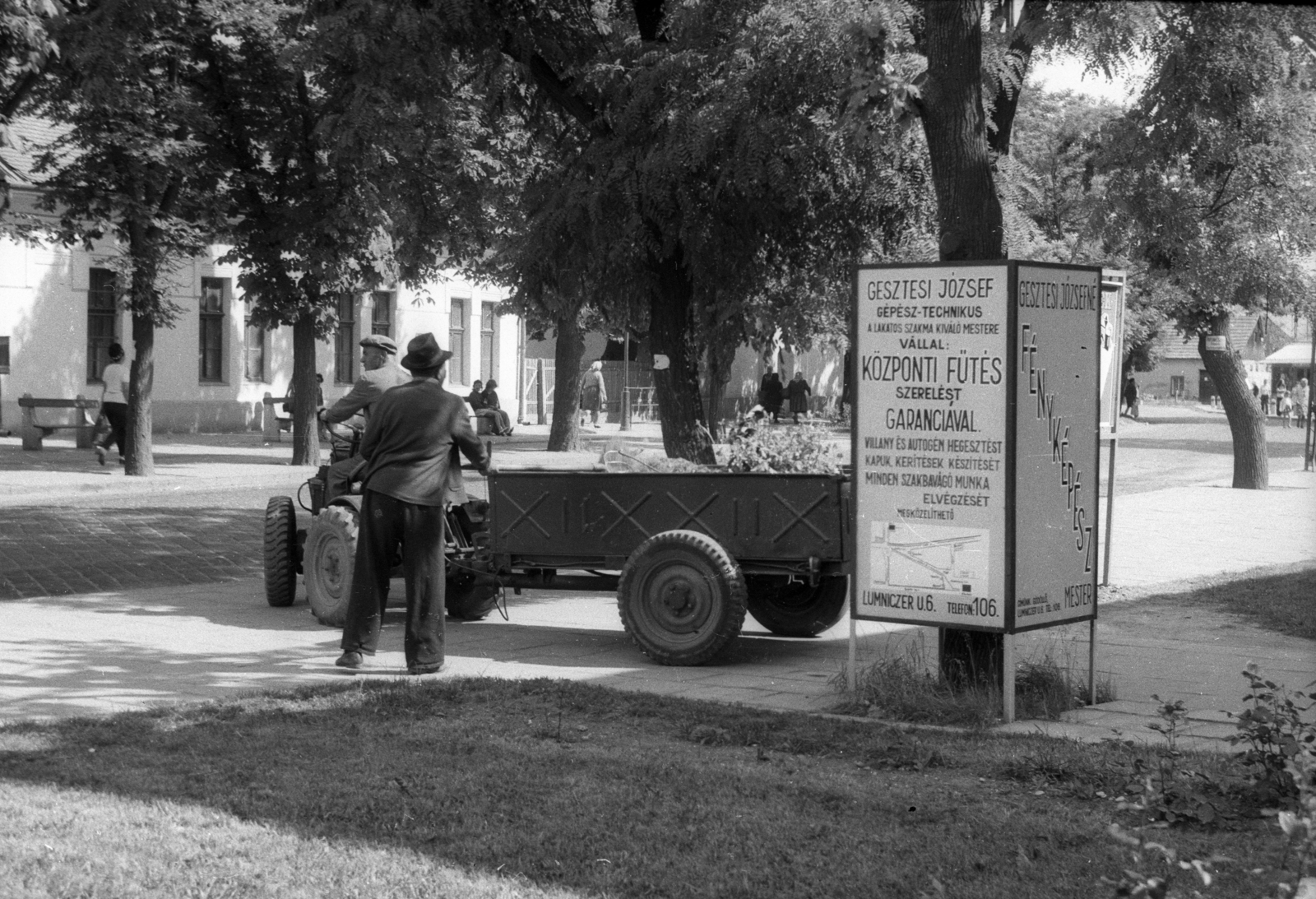 Magyarország, Gödöllő, Szabadság tér., 1976, Berkó Pál, reklám, utcakép, életkép, pótkocsi, hirdetőoszlop, traktor, fasor, pad, Gesztesi József, Fortepan #78404