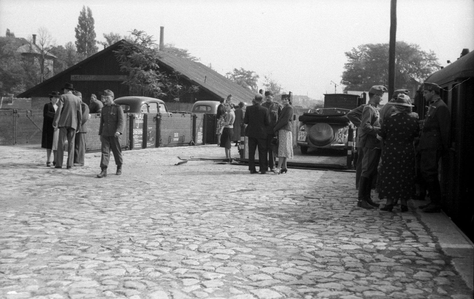 Hungary, Budapest VI.,Budapest XIII., MÁV üzemi terület a Nyugati pályaudvar külső vágányai a Dózsa György (Aréna) út közelében, a háttérben a kép bal szélén a Szabolcs utcai kórház., 1939, Berkó Pál, railway, soldier, automobile, number plate, Budapest, Fortepan #78523