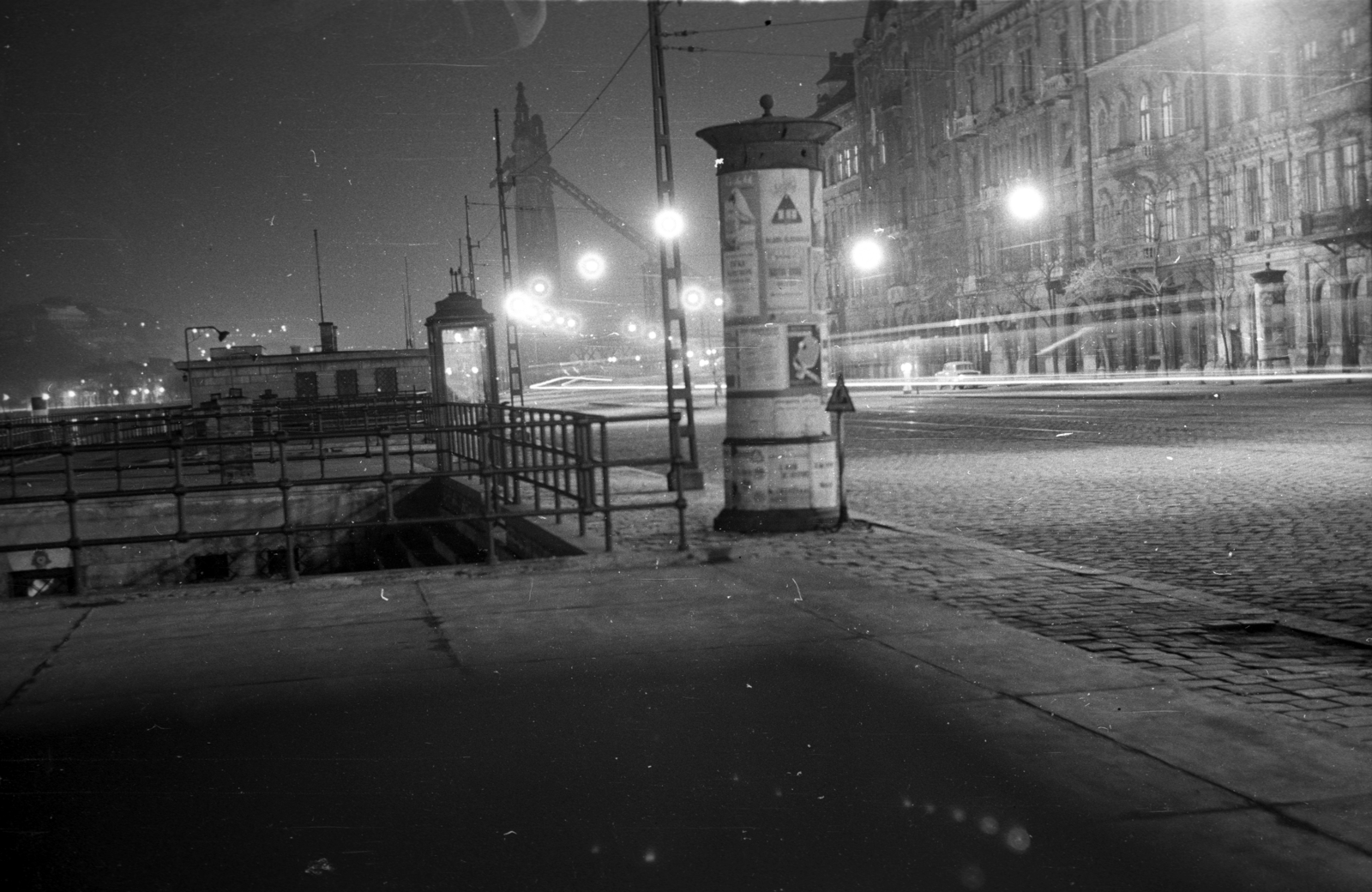 Hungary, Budapest V., Belgrád rakpart a MAHART nemzetközi hajóállomásánál, háttérben a lerombolt Erzsébet híd pesti hídfője., 1959, Berkó Pál, war damage, night, ad pillar, wrecked bridge, eclectic architecture, Budapest, Duna-bridge, Antal Kherndl-design, Aurél Czekelius-design, Fortepan #78738