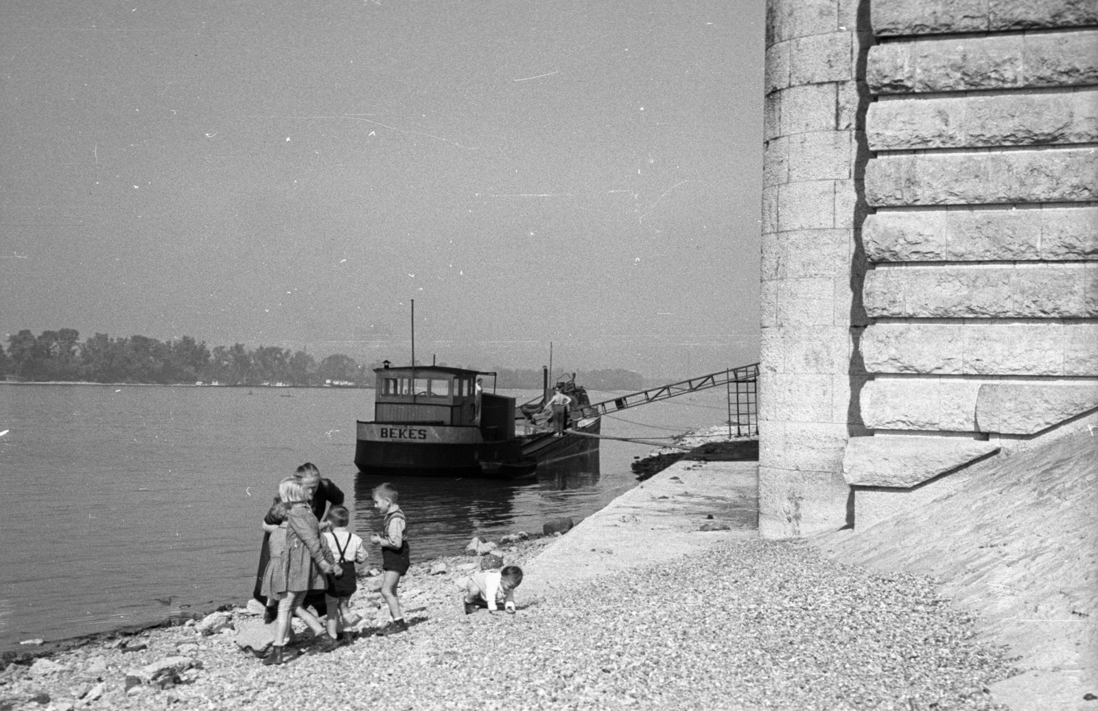 Magyarország, Budapest XIII., angyalföldi Duna-part az Árpád (Sztálin) híd hídfőjénél, szemben a Hajógyári-sziget., 1955, Berkó Pál, Budapest, hajó, nagyszülő, folyópart, unoka, kavics, Fortepan #78776