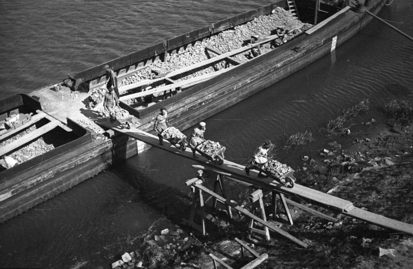 Hungary, Budapest XX.,Budapest XXI., partépítés a Csepel-szigeten a Ráckevei (Soroksári)-Dunánál a Gubacsi hídról nézve., 1948, Berkó Pál, construction, barge, work, shore, wheelbarrow, plank, Budapest, Danube's shore, construction worker, Fortepan #78913
