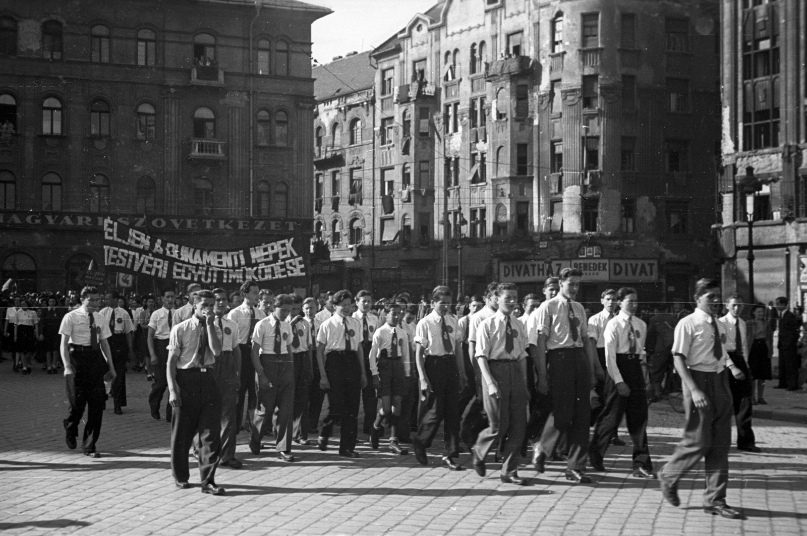 Magyarország, Budapest VIII., a Népszínház utca a Nagy Fuvaros utca és a Bérkocsis utca felé nézve, május 1-i felvonulás., 1946, Berkó Pál, Budapest, férfiak, tömeg, jelmondat, egyenruha, Fortepan #79266