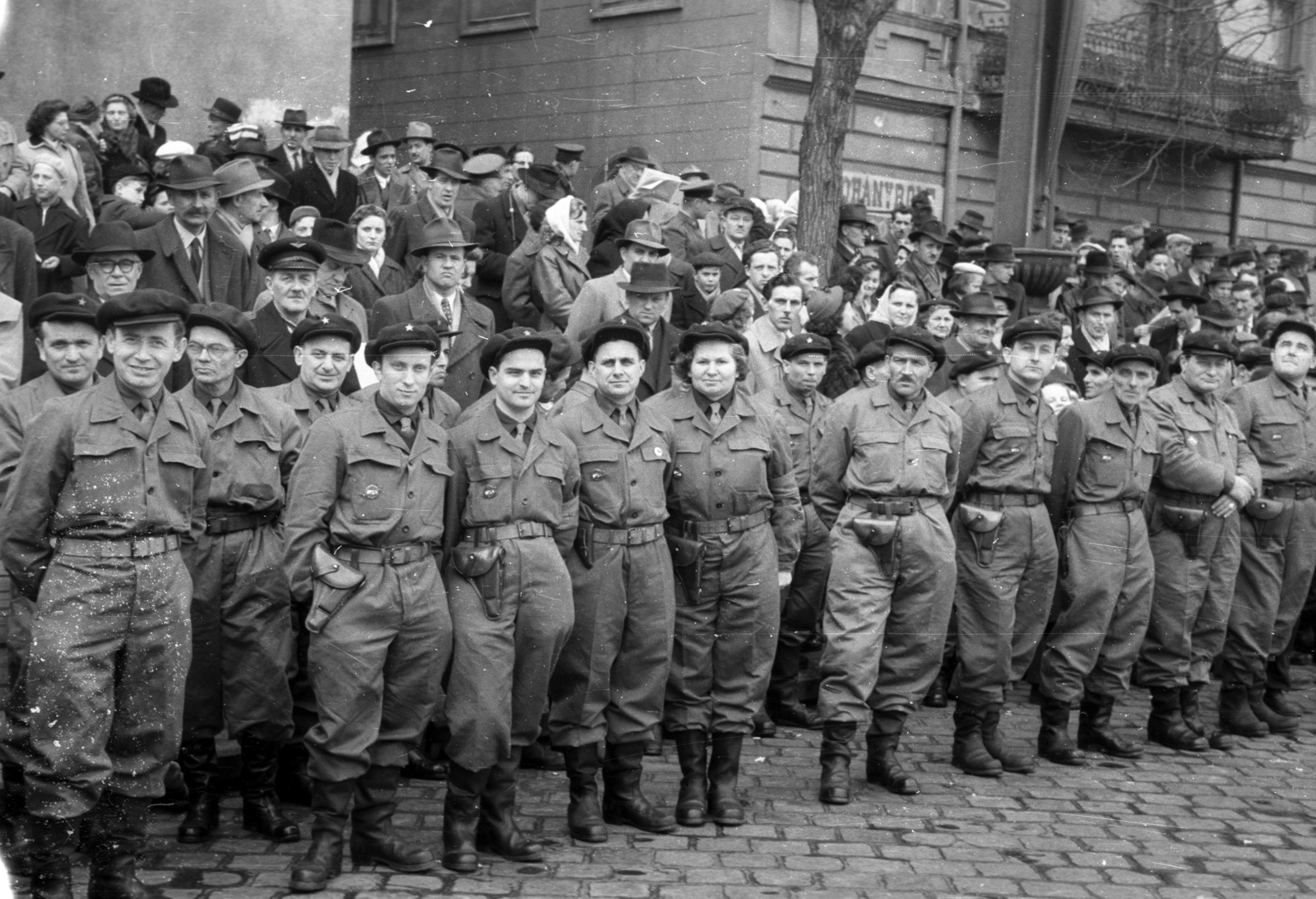 Magyarország, Budapest VII., Április 4-i katonai díszszemle nézőközönsége a Dózsa György út 68. és 70. előtt., 1958, Berkó Pál, egyenruha, munkásőr, pisztolytáska, Budapest, trafik, Fortepan #79381