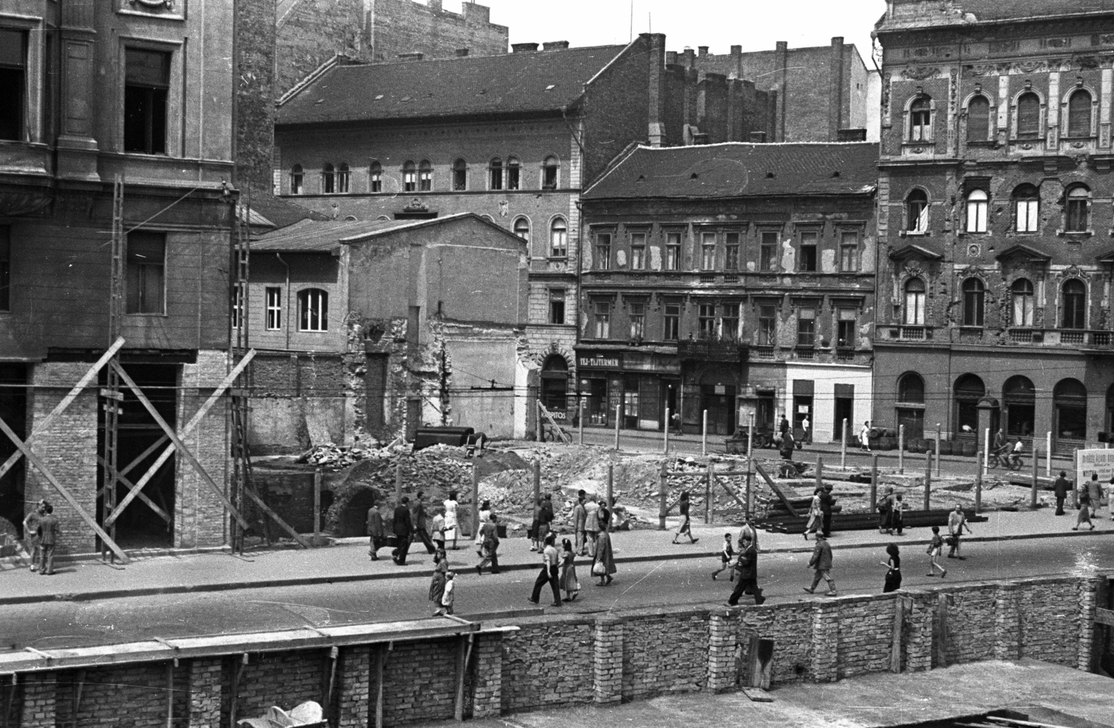 Magyarország, Budapest VIII.,Budapest VII., Blaha Lujza tér, szemben az Akácfa utca., 1955, UVATERV, Budapest, járókelő, tejbolt, téglakerítés, kárpitos, munkatér-határolás, építőanyag, Fortepan #79820