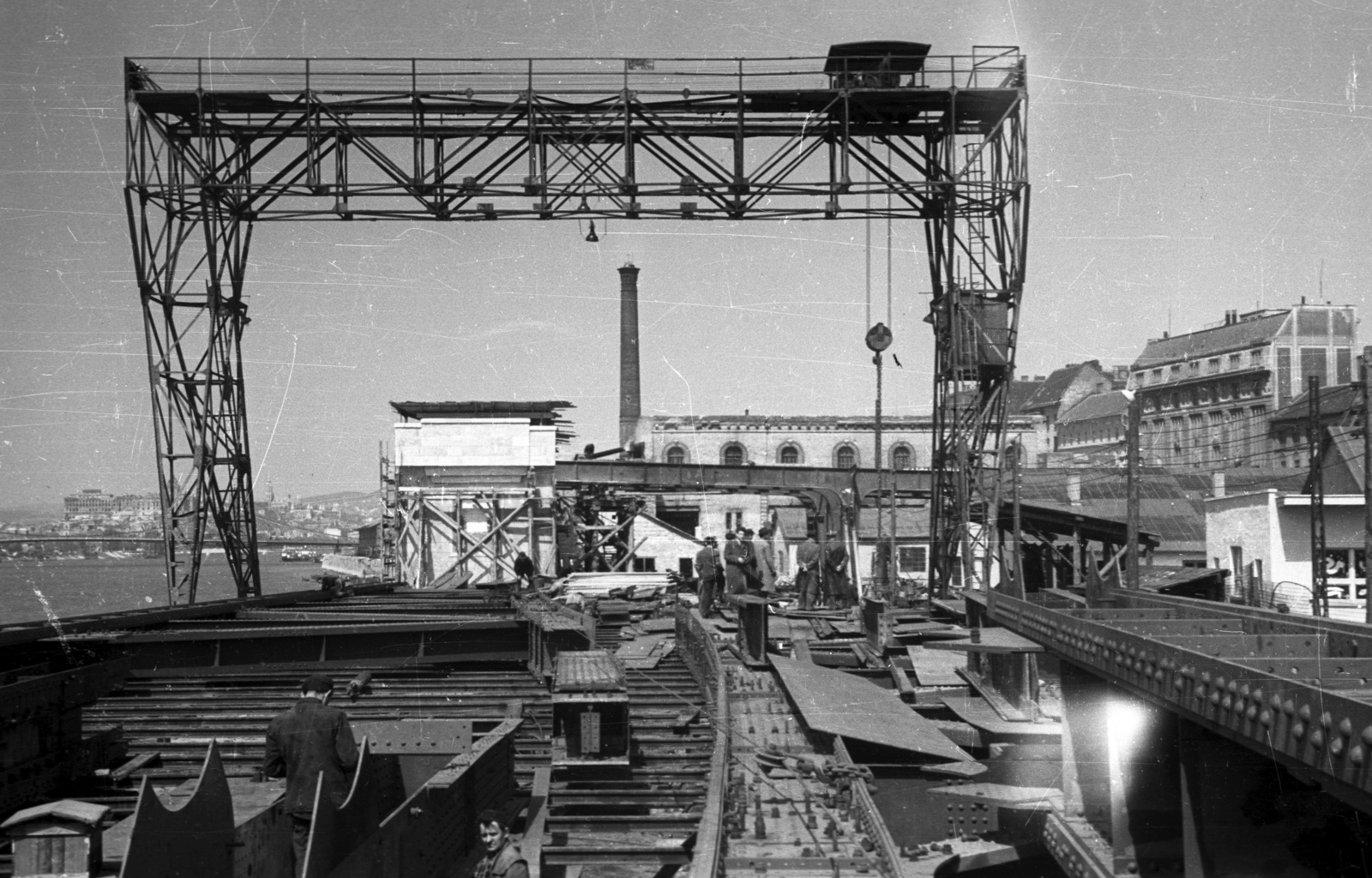 Magyarország, Budapest IX., a Petőfi híd újjáépítése, az acélszerkezet szerelése a pesti hídfőnél. Háttérben az Elevátor-ház maradványa., 1951, UVATERV, híd, folyó, férfiak, daru, munka, Budapest, Fortepan #79927