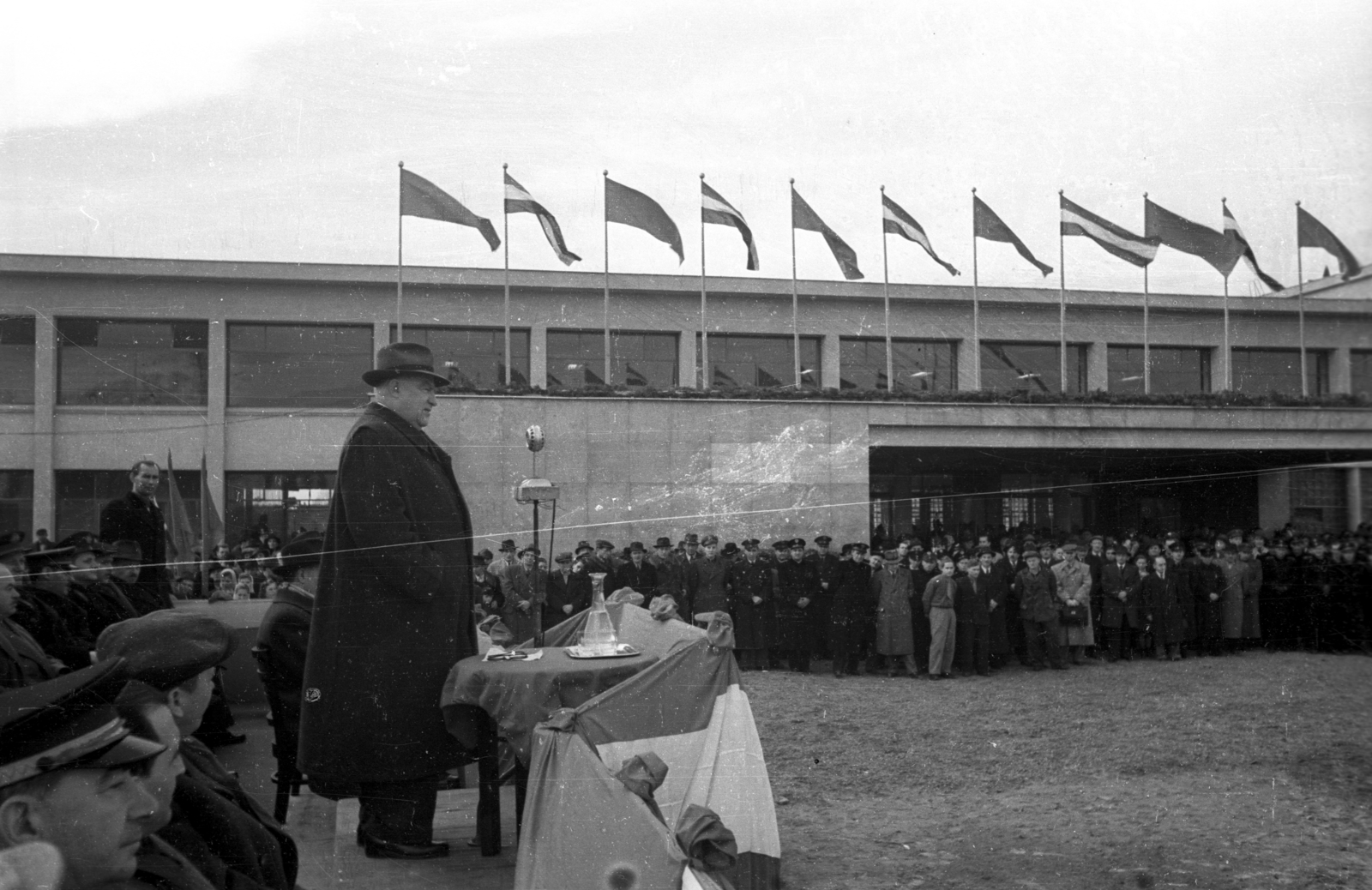 Magyarország, Nyíregyháza, Állomás tér, az újjáépített vasútállomás avató ünnepsége. A mikrofon mögött Bebrits Lajos közlekedési miniszter., 1951, UVATERV, mikrofon, tribün, karaf, Fortepan #79989