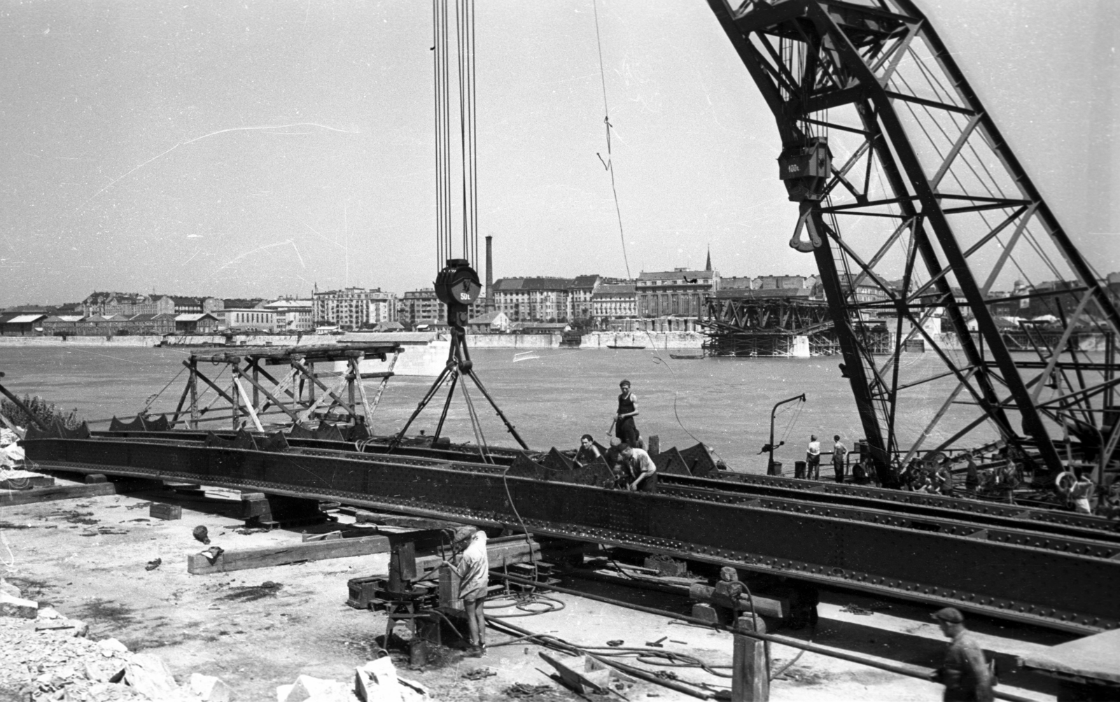 Hungary, Budapest XI., Lágymányosi rakpart, úszódaru az újjáépülő Petőfi híd elemeivel, háttérben a Közraktár utca épületei., 1951, UVATERV, bridge building, Budapest, Fortepan #80038