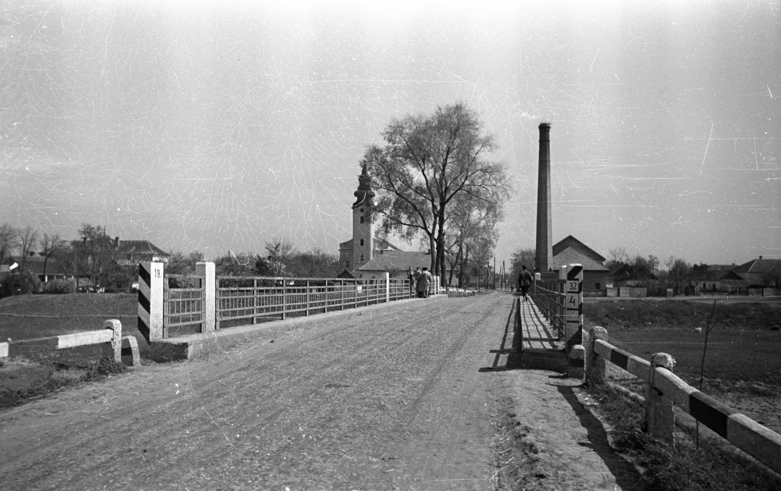 Hungary, Jásztelek, Alkotmány út a Zagyva hídnál, szemben a katolikus templom., 1951, UVATERV, church, bridge, chimney, Fortepan #80174