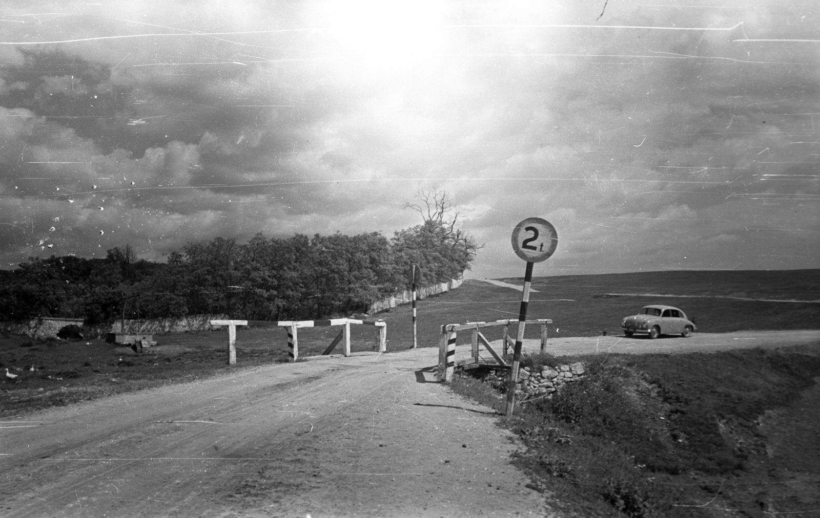 Magyarország, Csákberény, Rákóczi utca a község határában, kelet felé nézve. Középen a Kis-kút árok áteresze., 1950, UVATERV, csehszlovák gyártmány, Tatra-márka, automobil, Tatra 600 Tatraplan, fahíd, Fortepan #80188