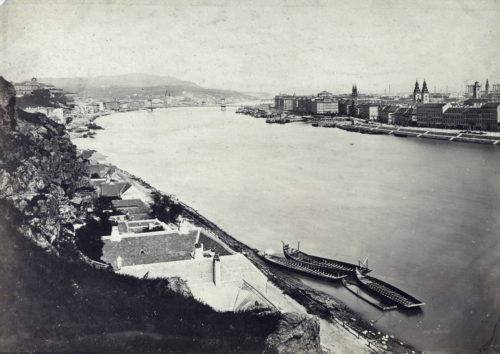 Magyarország, Budapest XI., kilátás a Gellérthegyről a Széchenyi Lánchíd és az épülő Margit híd felé. A felvétel 1874 körül készült. A kép forrását kérjük így adja meg: Fortepan / Budapest Főváros Levéltára. Levéltári jelzet: HU.BFL.XV.19.d.1.05.055, 1900, Budapest Főváros Levéltára / Klösz György fényképei, Klösz György, Budapest, függőhíd, William Tierney Clark-terv, Duna, uszály, háztető, torony, Fortepan #82110