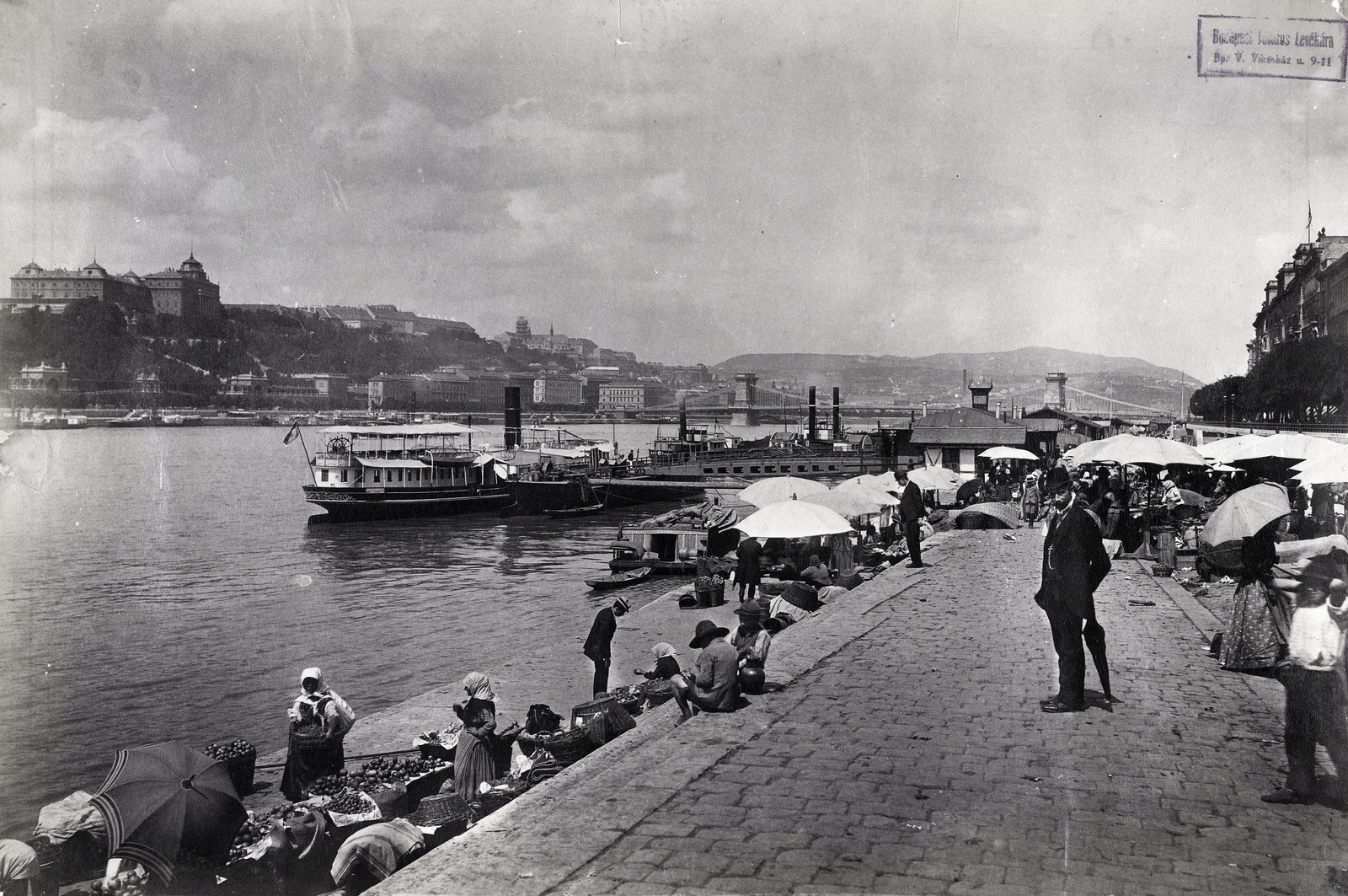 Magyarország, Budapest V., pesti alsó rakpart, piac a Petőfi téri hajóállomásnál. Balra a Királyi Palota (később Budavári Palota), távolban a Széchenyi Lánchíd látszik. A felvétel 1893 körül készült. A kép forrását kérjük így adja meg: Fortepan / Budapest Főváros Levéltára. Levéltári jelzet: HU.BFL.XV.19.d.1.07.004, 1900, Budapest Főváros Levéltára / Klösz György fényképei, Klösz György, piac, rakpart, gőzhajó, Budapest, függőhíd, William Tierney Clark-terv, Fortepan #82328