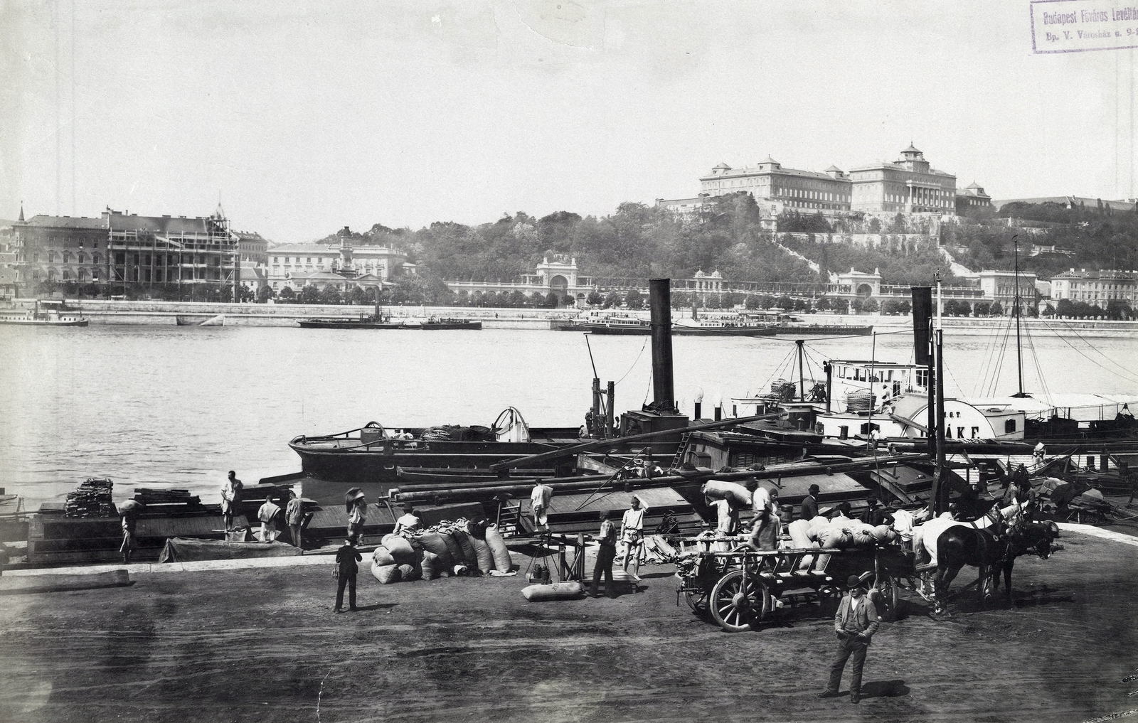 Magyarország, Budapest V., kikötő a pesti alsó rakpartnál. A Duna túlpartján a Várkert Bazár és a Királyi Palota (később Budavári Palota). A felvétel 1893 körül készült. A kép forrását kérjük így adja meg: Fortepan / Budapest Főváros Levéltára. Levéltári jelzet: HU.BFL.XV.19.d.1.07.161, 1900, Budapest Főváros Levéltára / Klösz György fényképei, Klösz György, hajó, szekér, építkezés, fogat, vontatóhajó, zsák, gőzhajó, lapátkerekes hajó, rakodás, Fertő/Deák Ferencz/Vorwärts hajó, Budapest, Trinitas hajó, Fortepan #82485