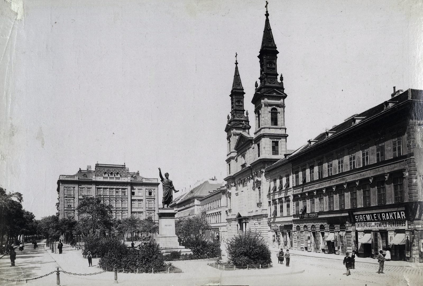 Hungary, Budapest V., Petőfi tér, Petőfi Sándor szobra (Huszár Andor, 1882.), jobbra a Nagyboldogasszony ortodox székesegyház. A felvétel 1899 körül készült. A kép forrását kérjük így adja meg: Fortepan / Budapest Főváros Levéltára. Levéltári jelzet: HU.BFL.XV.19.d.1.08.071, 1900, Budapest Főváros Levéltára / Klösz György fényképei, Klösz György, sculpture, store display, Petőfi-portrayal, Budapest, Fortepan #82596
