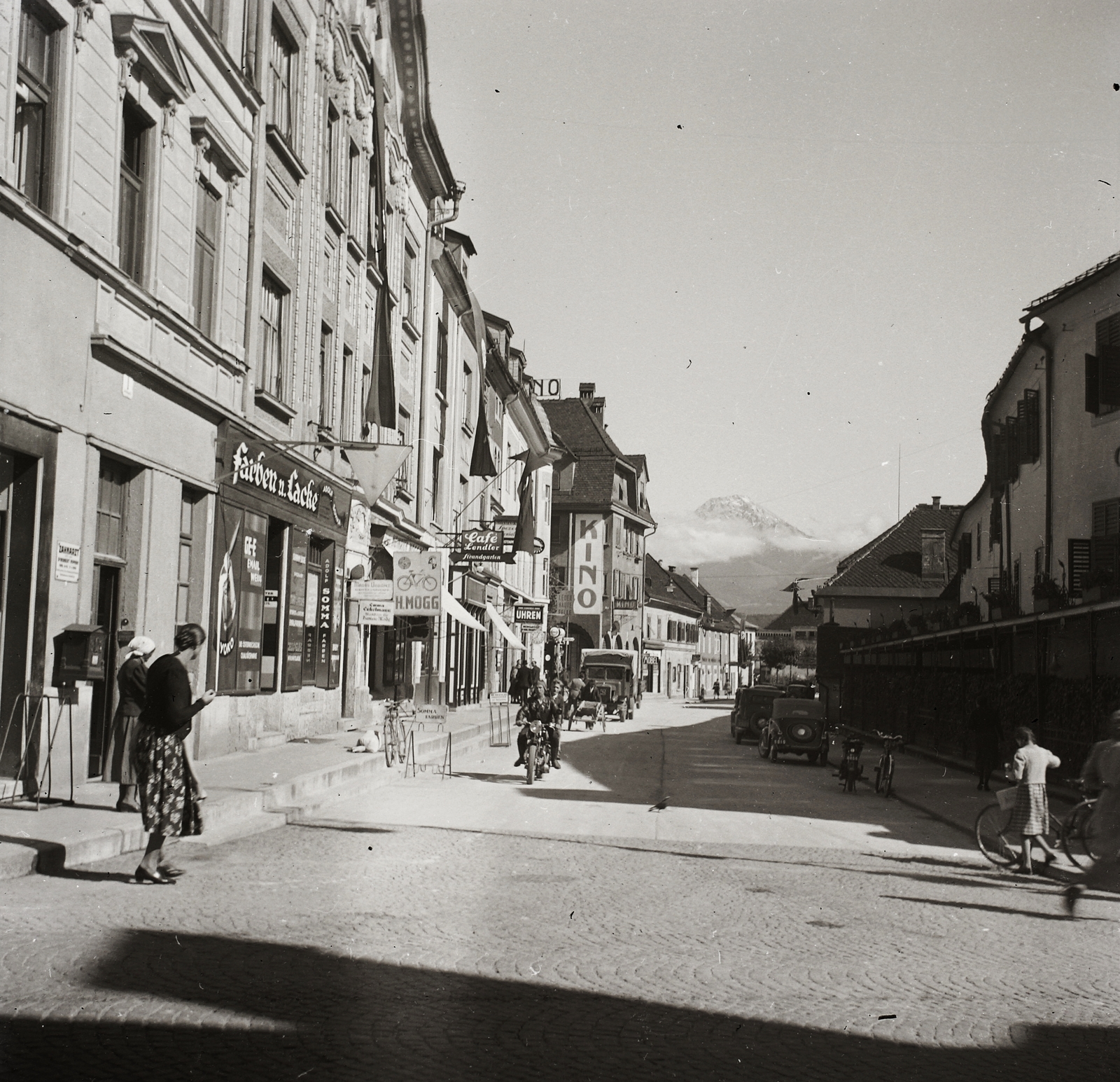 Ausztria, Villach, Gerbergasse., 1939, Ebner, kerékpár, motorkerékpár, teherautó, utcakép, hegy, postaláda, kockakő, mozi, automobil, Fortepan #83870