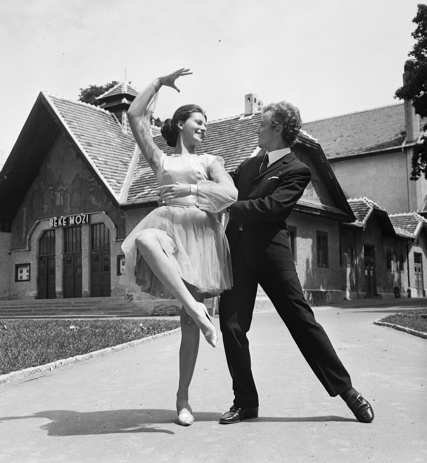 Magyarország, Nagykanizsa, park a Sugár út - Rozgonyi utca sarkán, háttérben a Béke Mozi (eredetileg Városi Színház)., 1971, MHSZ, tánc, mozi, táncos, Fortepan #84543