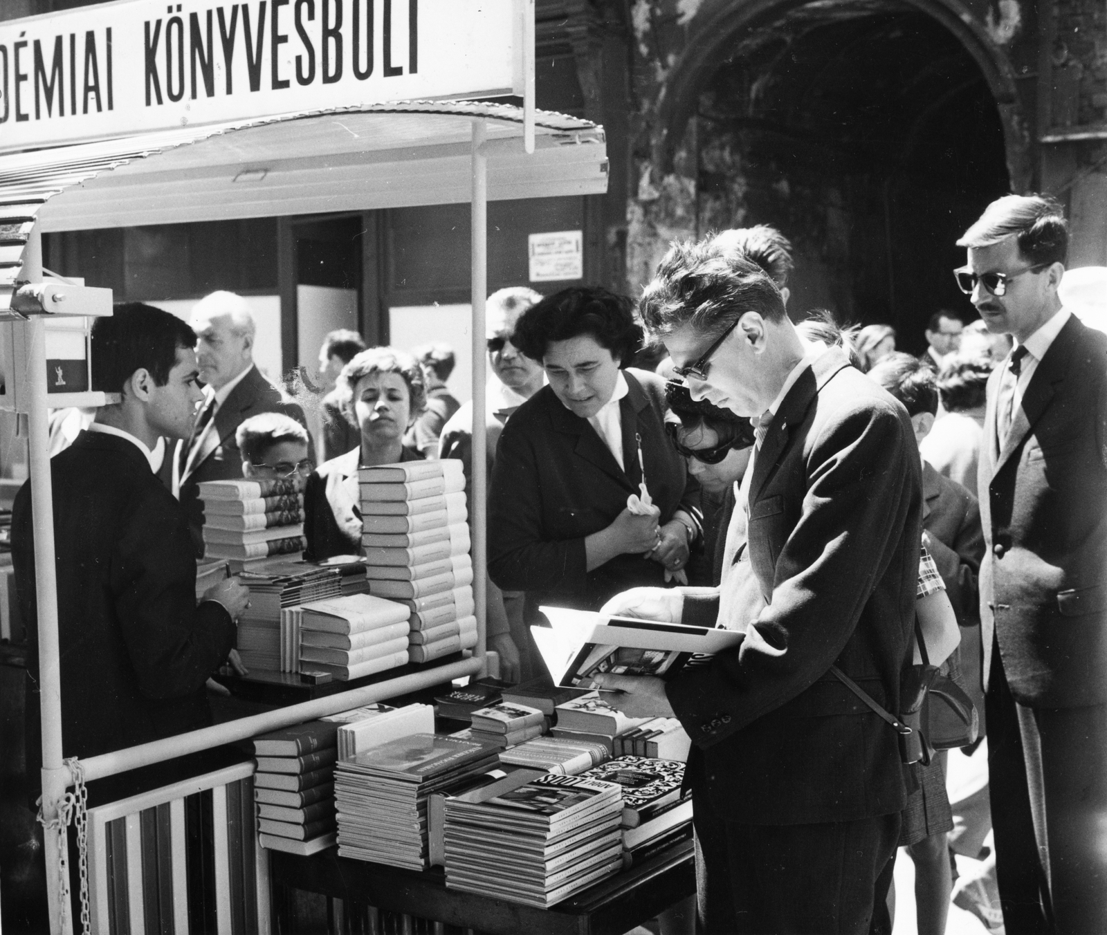 Magyarország, Budapest V., Váci utca, a felvétel az Akadémiai Könyvesbolt előtt készült az Ünnepi könyvhéten., 1967, Magyar Hírek folyóirat, életkép, napszemüveg, Budapest, könyvárus, Fortepan #84679