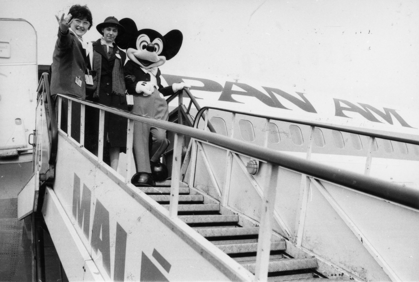 Magyarország, Ferihegyi (ma Liszt Ferenc) repülőtér, Budapest XVIII., kalapban Melissa Tyler Wackerman, Disneyland nagykövete Mickey egér (Mickey Mouse) rajzfilmfigurájával., 1985, Magyar Hírek folyóirat, repülőgép, jelmez, repülőtér, MALÉV légitársaság, Budapest, Pan Am légitársaság, reptéri lépcső, Miki Egér, Fortepan #84714
