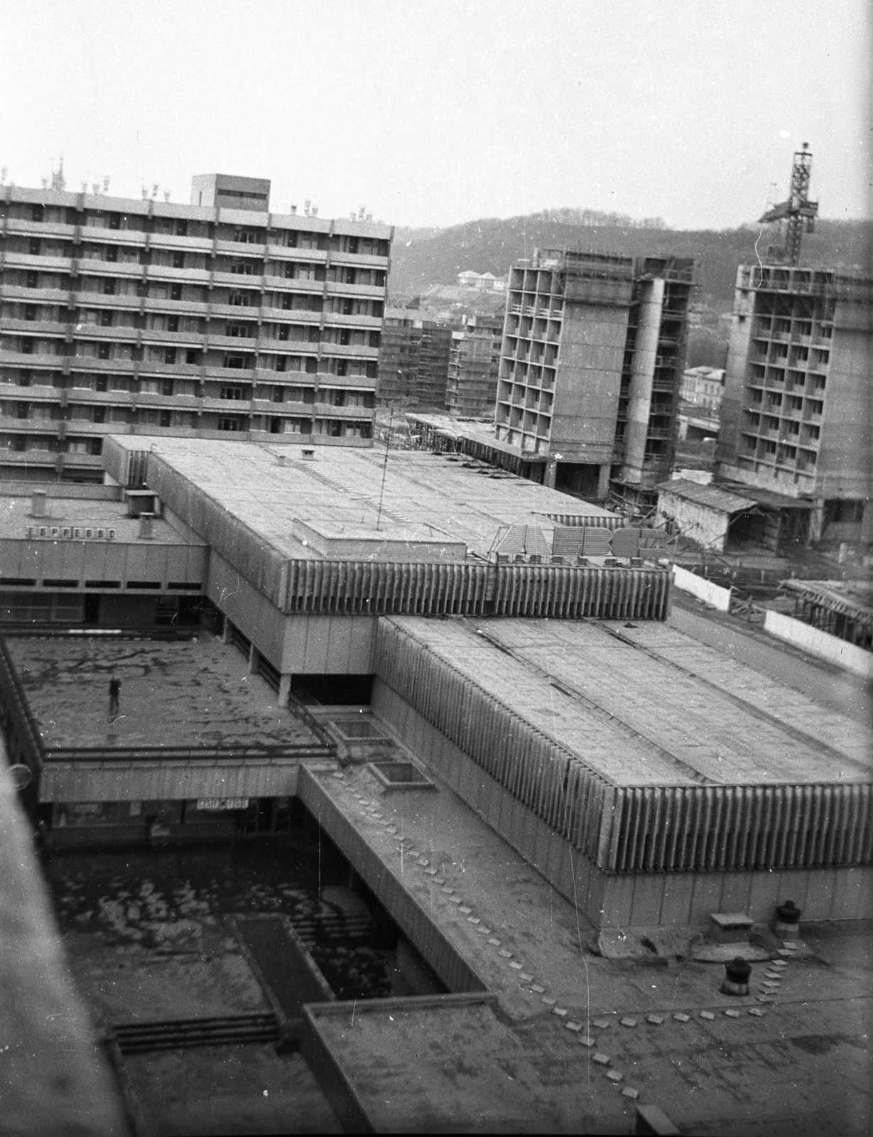 Hungary, Salgótarján, Rákóczi út, üzletház a Pécskő út saroknál, jobbra az épülő garzonházak., 1973, Erdei Katalin, construction, tower crane, tall house, Fortepan #84970