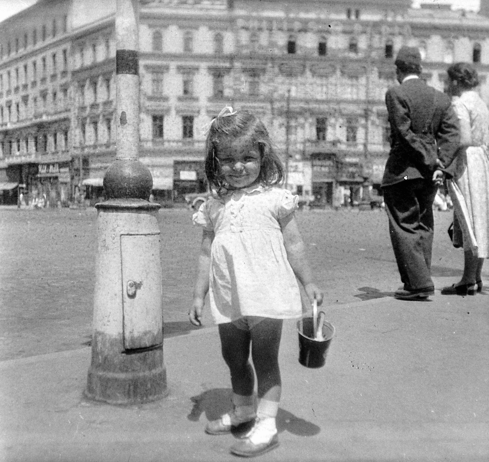 Hungary, Budapest VI., Oktogon, a háttérben a 4-es számú ház., 1949, Fortepan, portrait, girl, Budapest, hands behind the back, smile, summer dresses, ribbon, bucket, Fortepan #8512