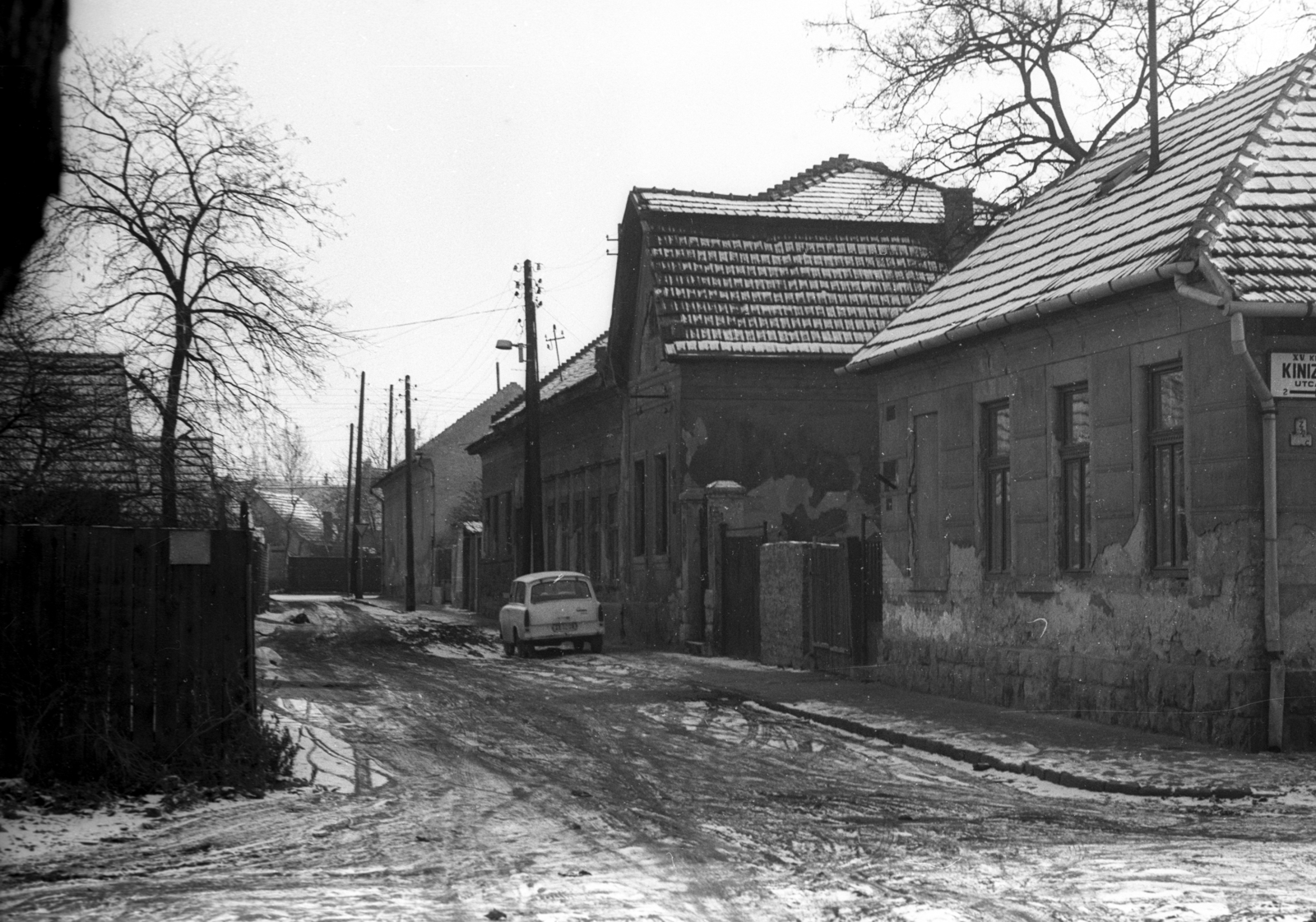 Magyarország, Budapest XV., Kinizsi utca, a mára elbontott telep, a "Sódergödör" házai., 1982, Czunya György, hó, Trabant-márka, földút, villanyoszlop, utcanévtábla, Budapest, Fortepan #85284