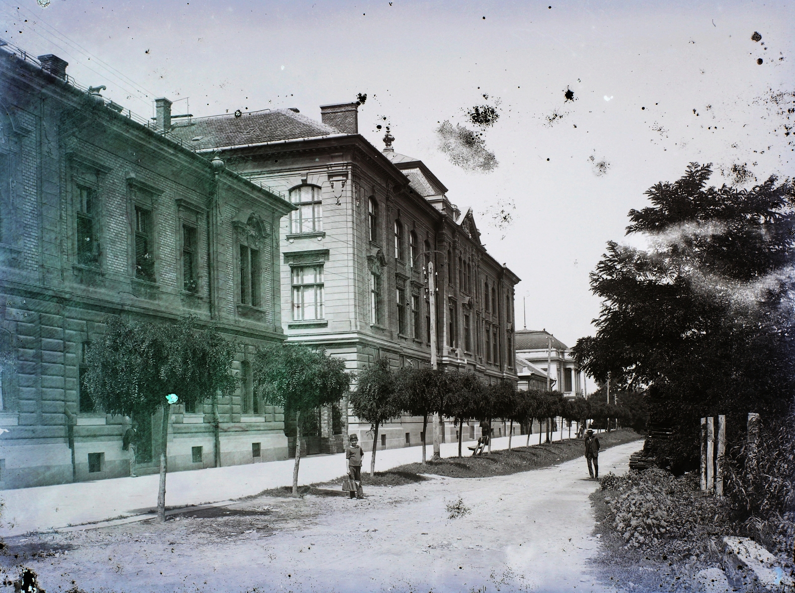 Romania,Transylvania, Lugoj, Eötvös sor (Strada Coriolan Brediceanu), középen a Főgimnázium (később Coriolan Brediceanu Nemzeti Kollégium), távolban a Városi Színház., 1910, Magyar Földrajzi Múzeum / Erdélyi Mór cége, alley, public building, damaged photo, Fortepan #86667