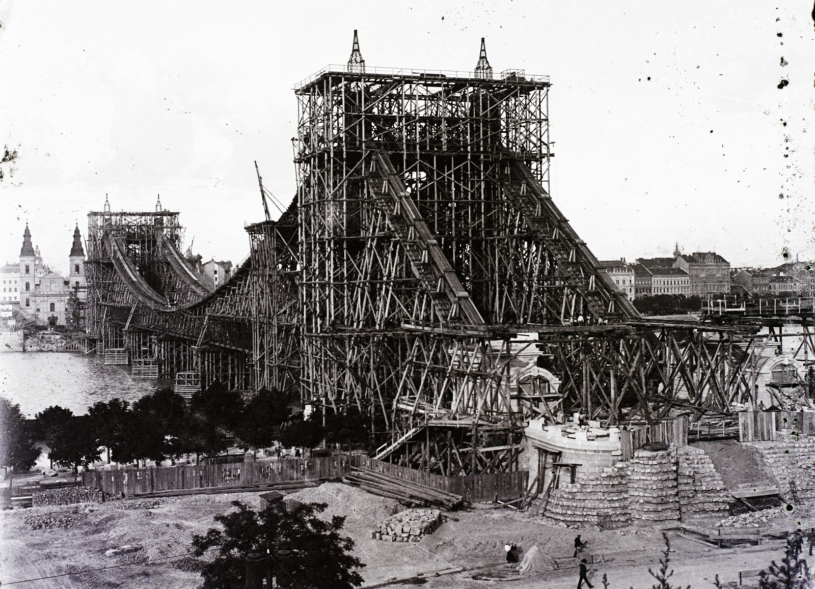 Hungary, Budapest V.,Budapest I., az épülő Erzsébet híd, szemben a pesti hídfőnél a Belvárosi templom., 1901, Magyar Földrajzi Múzeum / Erdélyi Mór cége, bridge building, Danube, eclectic architecture, Budapest, suspension bridge, Duna-bridge, Antal Kherndl-design, Aurél Czekelius-design, scaffolding, Fortepan #86703