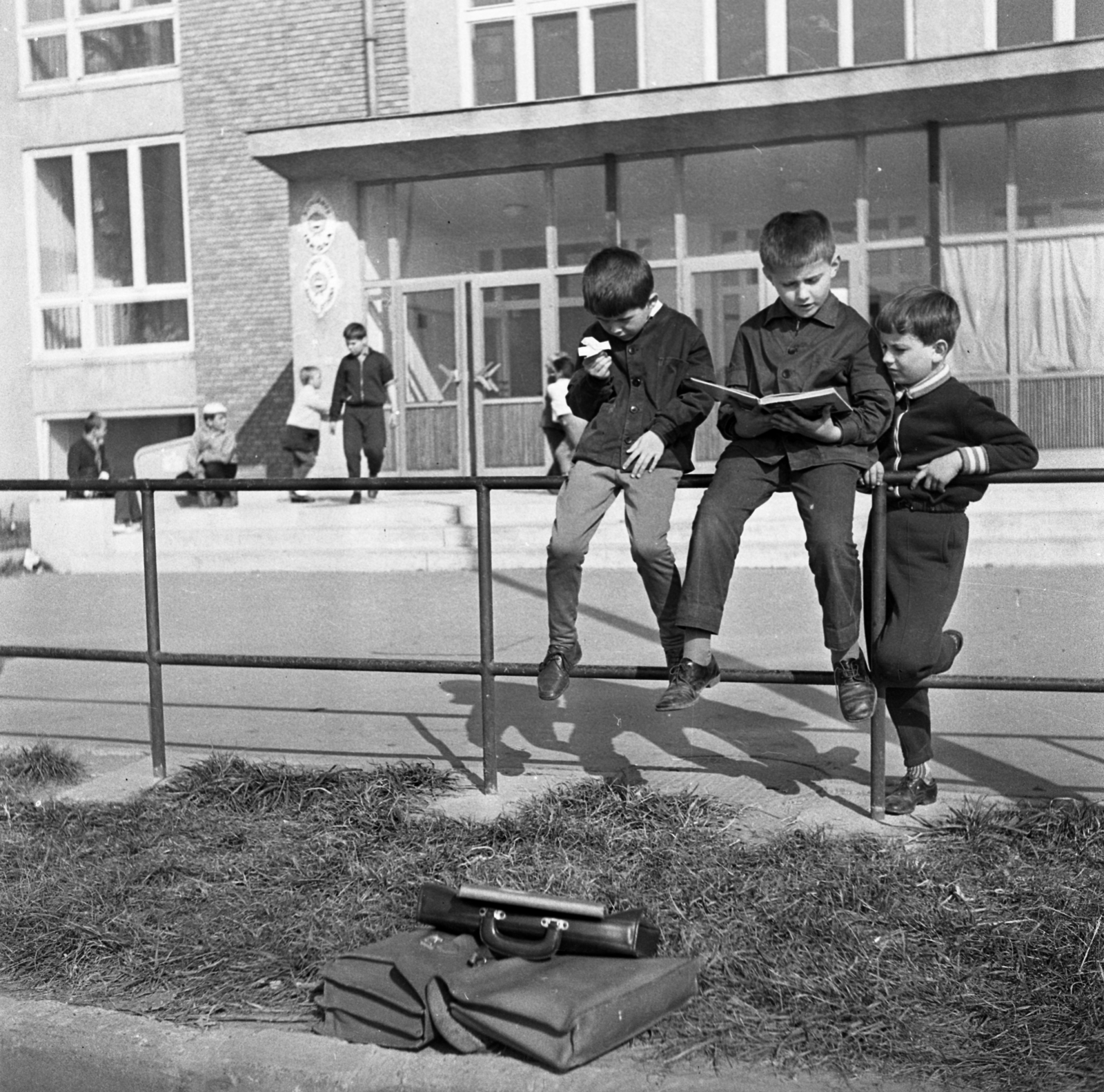 Hungary, Százhalombatta, Damjanich út 24., 1. Számú Általános Iskola., 1970, Urbán Tamás, school, reading, kids, crest, schoolbag, student, enamel sign, sitting on a handrail, three people, Fortepan #89638