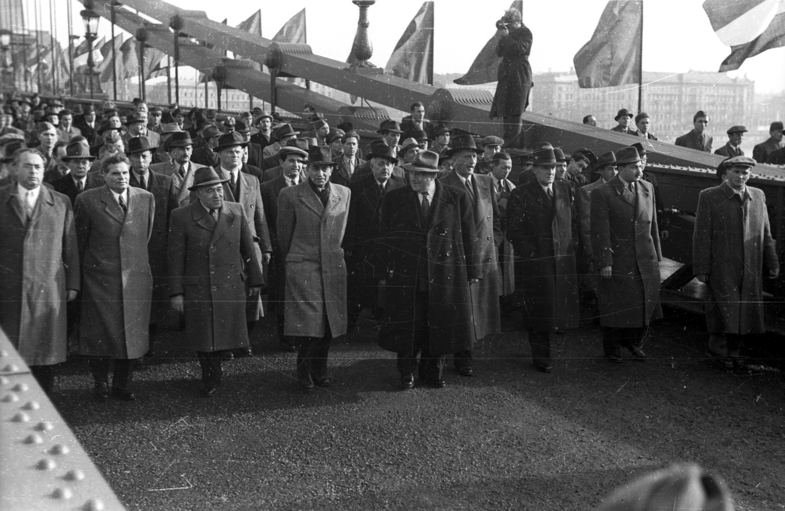 Hungary, Budapest, a Széchenyi Lánchíd. Az újjáépített híd átadási ünnepsége, a menet élén Vas Zoltán, Dobi István, Rákosi Mátyás, Gerő Ernő, Bebrits Lajos, kettővel mellette Kádár János., 1949, UVATERV, celebrity, mass, festive, politics, photography, suspension bridge, Duna-bridge, bunting, politician, William Tierney Clark-design, Fortepan #92011