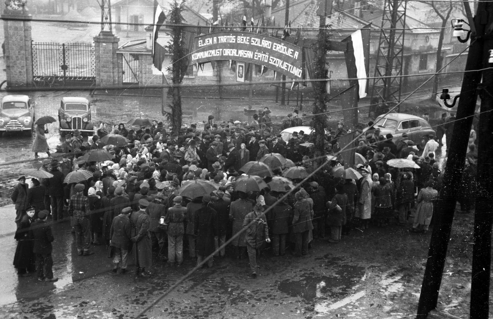 Magyarország, Szerencs, Gyár út - Rákóczi út sarok, gyűlés a balra látható Szerencsi Cukorgyár főkapuja előtt., 1951, UVATERV, GAZ M20 Pobjeda, Skoda 1101/1102 Tudor, cukorfinomító, cukorgyártás, jelmondat, esernyő, munkásgyűlés, Fortepan #92063