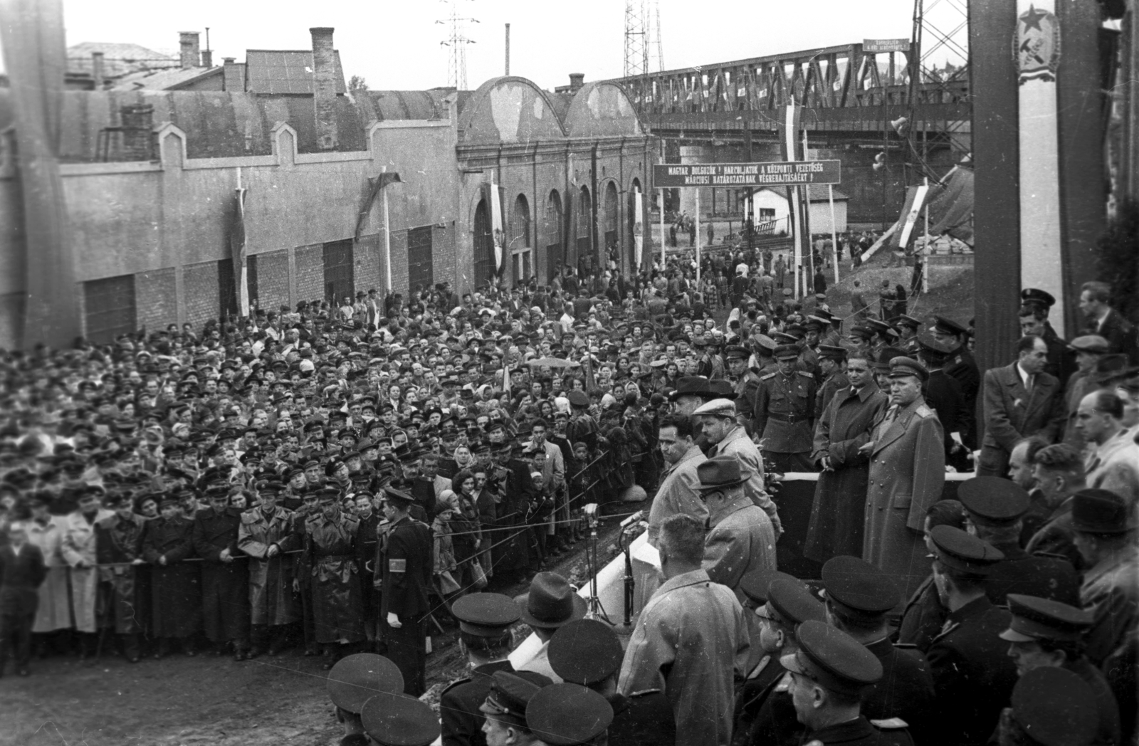 Hungary, Budapest XIII., az újjáépített Újpesti vasúti híd átadási ünnepsége. A szónok Bebrits Lajos közlekedési miniszter, mögötte sapkával Kovács István budapesti párttitkár. Balra az Újpest kocsiszín., 1955, UVATERV, Budapest, mass, politician, slogan, peaked cap, Fortepan #92070