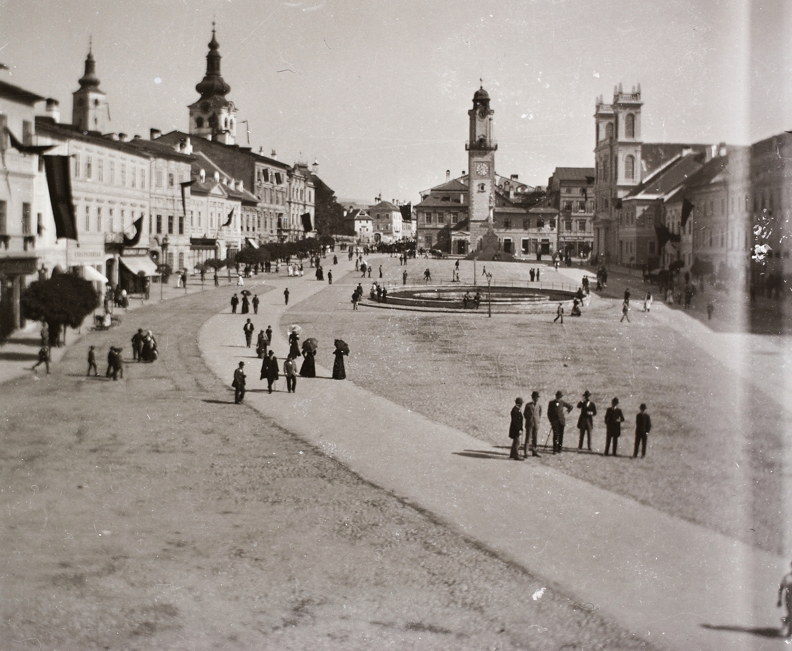 Slovakia, Banská Bystrica, Szlovák Nemzeti Felkelés (Slovenského národného povstania) tér (IV. Béla király tér), szemben az Óratorony, jobbra a Xavéri Szent Ferenc-székesegyház., 1915, Ebner, flag, square, pedestrian, church clock, Cathedral, clock tower, Fortepan #92436
