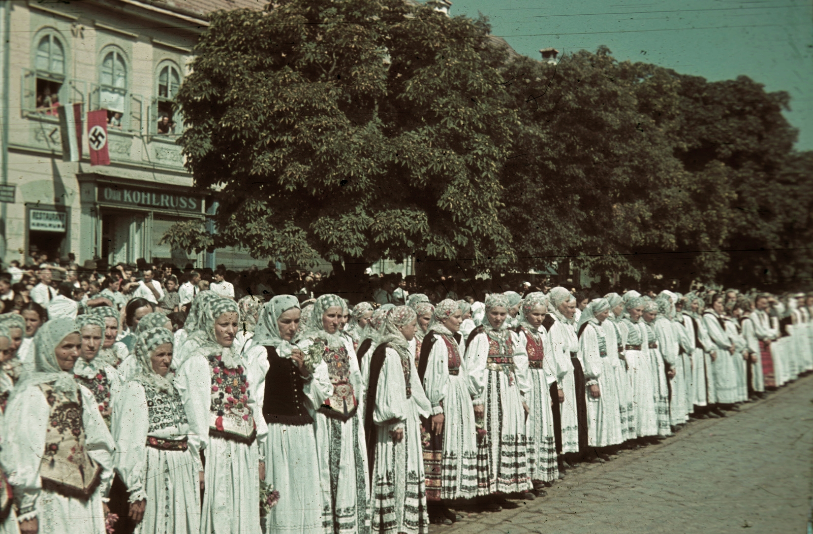 Romania,Transylvania, Bistrița, Fa utca (strada Liviu Rebreanu), lányok szász népviseletben a magyar csapatok bevonulása idején. A felvétel 1940. szeptember 8-án készült., 1940, Fortepan, territorial gain, colorful, flag, swastica, folk costume, Fortepan #92481