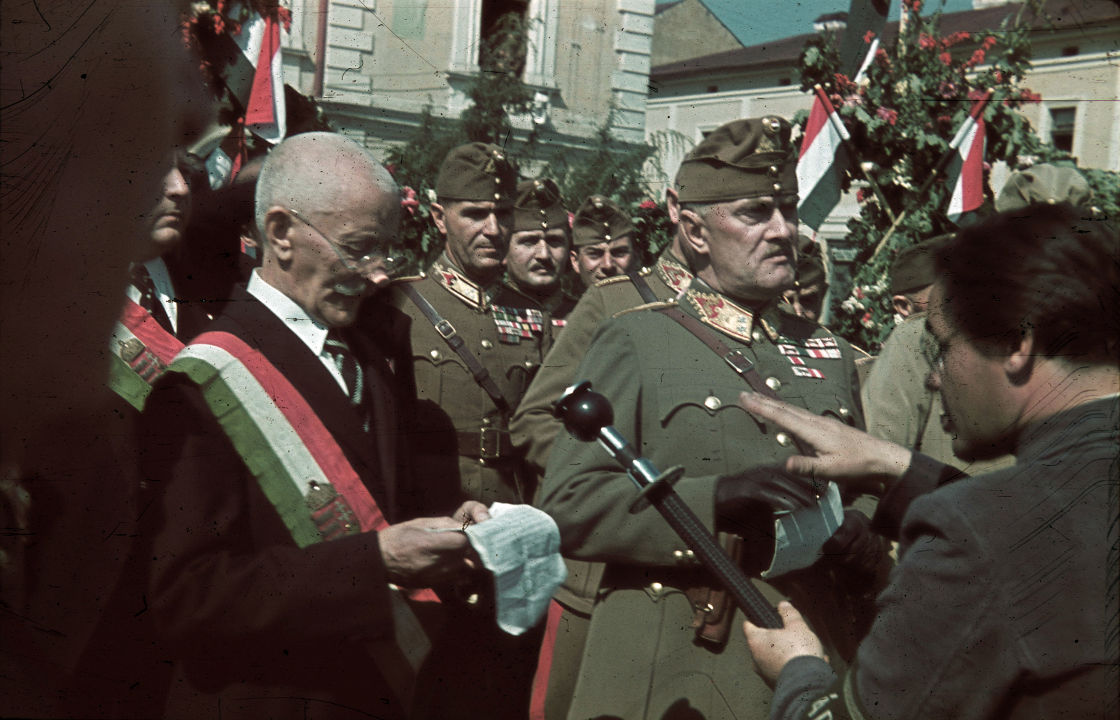 Romania,Transylvania, Sighetu Marmației, Fő tér (később Piata Libertătii), Gorondy-Novák Elemér altábornagy, a 3. hadsereg parancsnoka a fogadóbizottság köszöntő beszédét hallgatja. A felvétel 1940. szeptember 5-én a magyar csapatok bevonulása idején készült., 1940, Fortepan, territorial gain, colorful, flag, microphone, speech, posture, sash, "Bocskai" side cap, Fortepan #92483