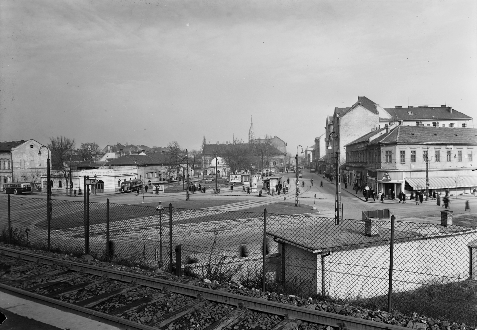 Hungary, Budapest X., Liget (Zalka Máté) tér, szemben a Kőrösi Csoma sétány (ekkor út), háttérben a Szent László-templom tornya., 1952, UVATERV, poster, cityscape, Ikarus-brand, tram, MÁVAG-brand, ad pillar, picture, bus stop, lamp post, newsstand, tram stop, Budapest, Fortepan #9263