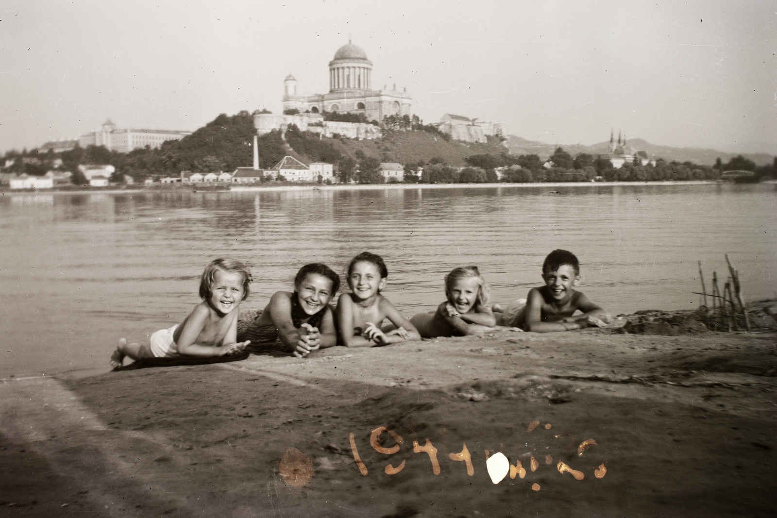 Magyarország,Szlovákia, Párkány, Duna-part, a túlparton Esztergom, a Várhegyen a Bazilika., 1944, Fortepan/Album002, Bazilika, Duna, gyerekek, csoportkép, vidámság, hason fekvés, Fortepan #92698
