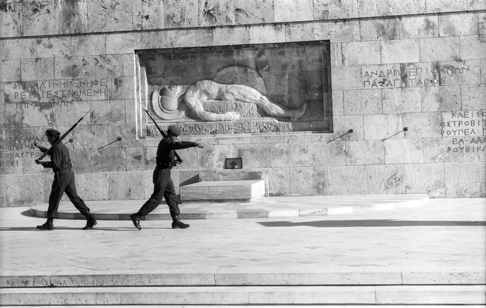 Greece, Athens, Szüntagma tér, őrségváltás a Parlament előtt. Háttérben az Ismeretlen katona sírjának márványból készült domborműve., 1964, Holenár Csaba és Edina, guard of honour, Greek alphabet, nude figure, Fortepan #93049