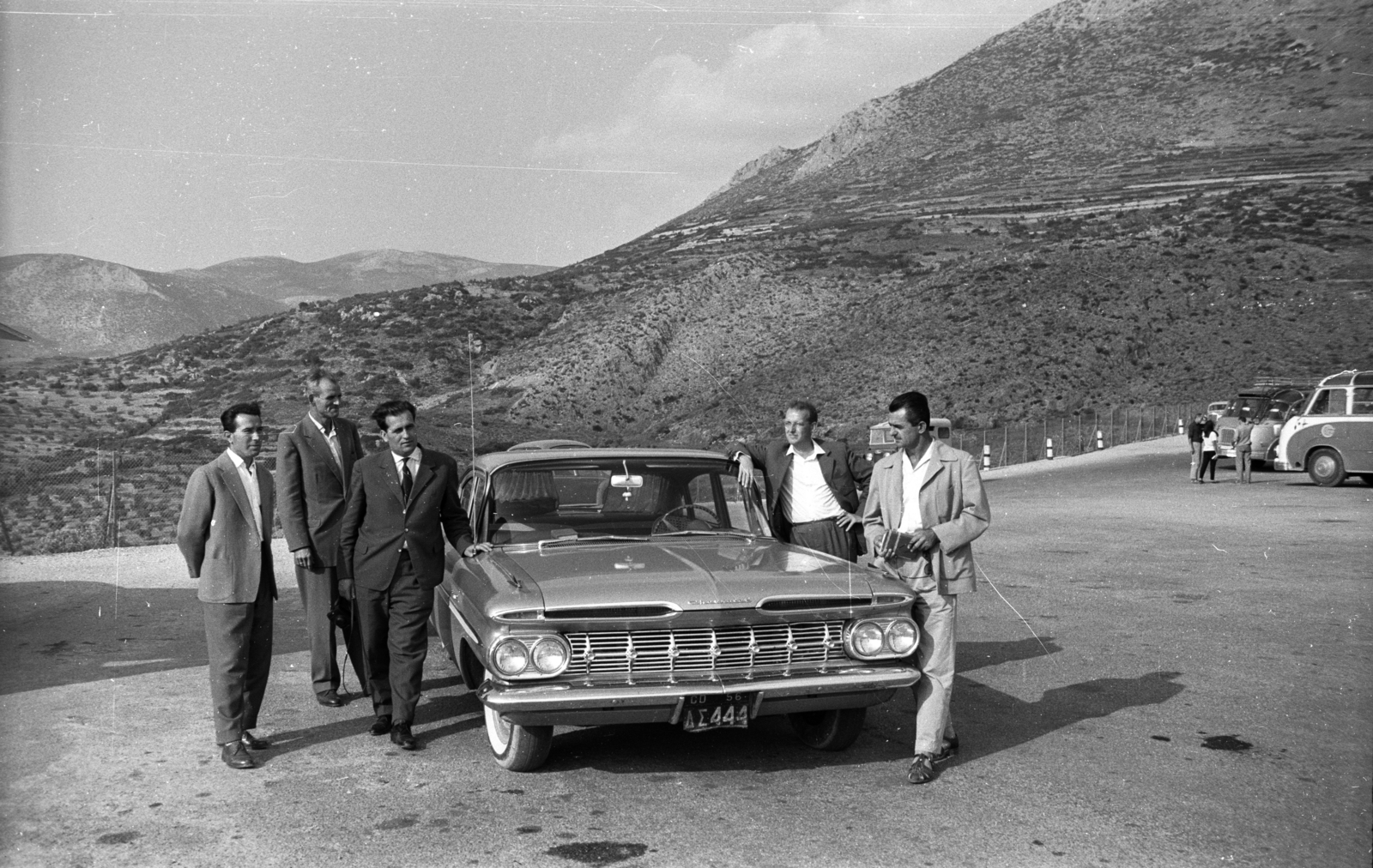 Greece, Mycenae, a romváros parkolója, háttérben a Zagrosz hegy és az Agiosz Iliasz hegy., 1964, Holenár Csaba és Edina, american brand, Chevrolet-brand, automobile, number plate, Greek alphabet, prop up on elbows, Fortepan #93063
