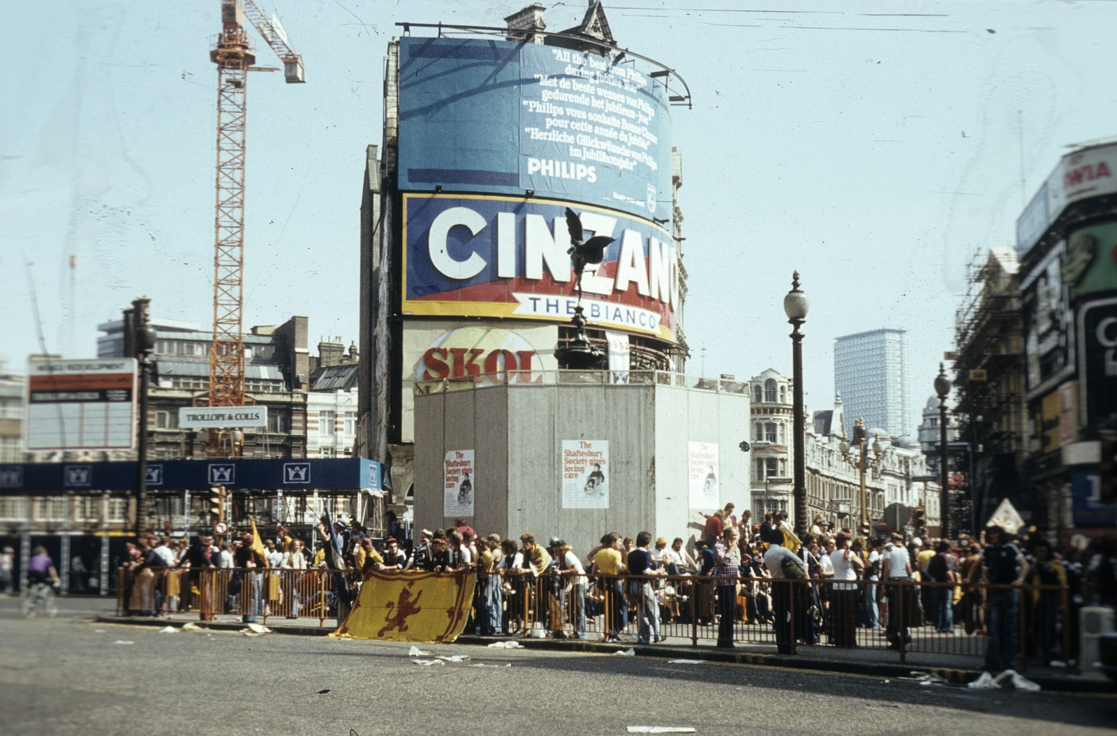 United Kingdom, London, Piccadilly Circus, a palánkkal körbvett Shaftesbury Memorial Fountain, jobbra a Shaftesbury Avenue., 1977, Közösségi Szociális Szövetkezet, ad, colorful, sculpture, crane, Fountain, Cinzano-brand, Skol-brand, Alfred Gilbert-design, Anteros-portrayal, Fortepan #93452
