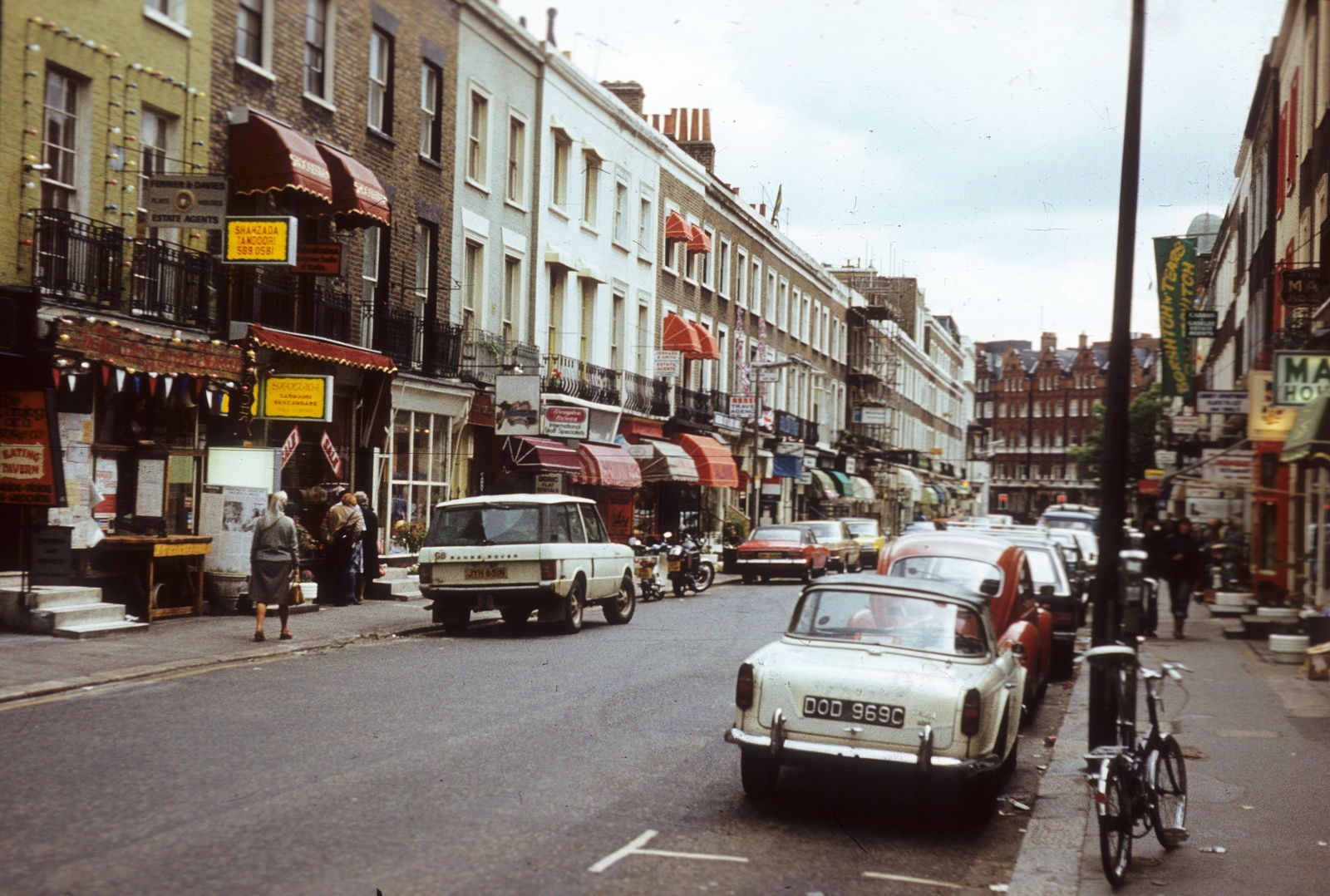 United Kingdom, London, Beauchamp Place a Brompton Road felé nézve., 1977, Közösségi Szociális Szövetkezet, bicycle, colorful, British brand, automobile, number plate, Land Rover-brand, awning, country code sign, Fortepan #93454