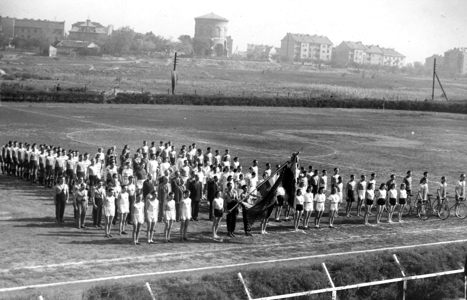 Hungary, Budapest XIV., Dózsa György (Aréna) út, Postás sporttelep, háttérben a Stefánia út, középen a Víztorony. A felvétel a Verseny utca irányából készült., 1938, Romák Éva, flag, water tower, pitch, Budapest, Fortepan #94068