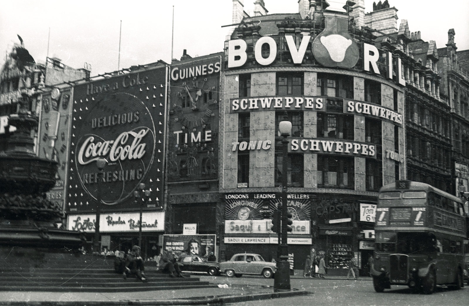 United Kingdom, London, Piccadilly Circus, Shaftesbury Memorial Fountain, jobbra a Shaftesbury Avenue., 1957, Vaskapu utca, ad, sculpture, pedestrian, street view, genre painting, neon sign, double-decker, automobile, Fortepan #94476