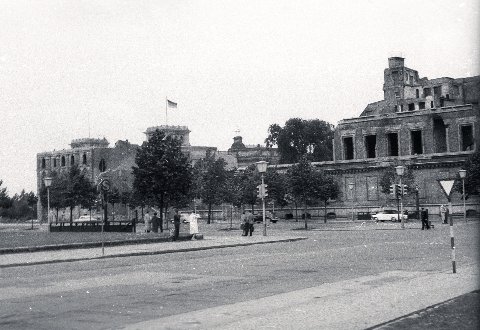 Németország, Berlin, Kelet-Berlin, Wilhelmstrasse az Unter den Linden kereszteződése előtt, bal szélen a Pariser Platz. Háttérben a nyugat-berlini oldalon a Reichstag., 1957, Vaskapu utca, utcakép, jelzőlámpa, neoreneszánsz, NDK, középület, országház, Kelet-Berlin, Nyugat-Berlin, Paul Wallot-terv, Fortepan #94483