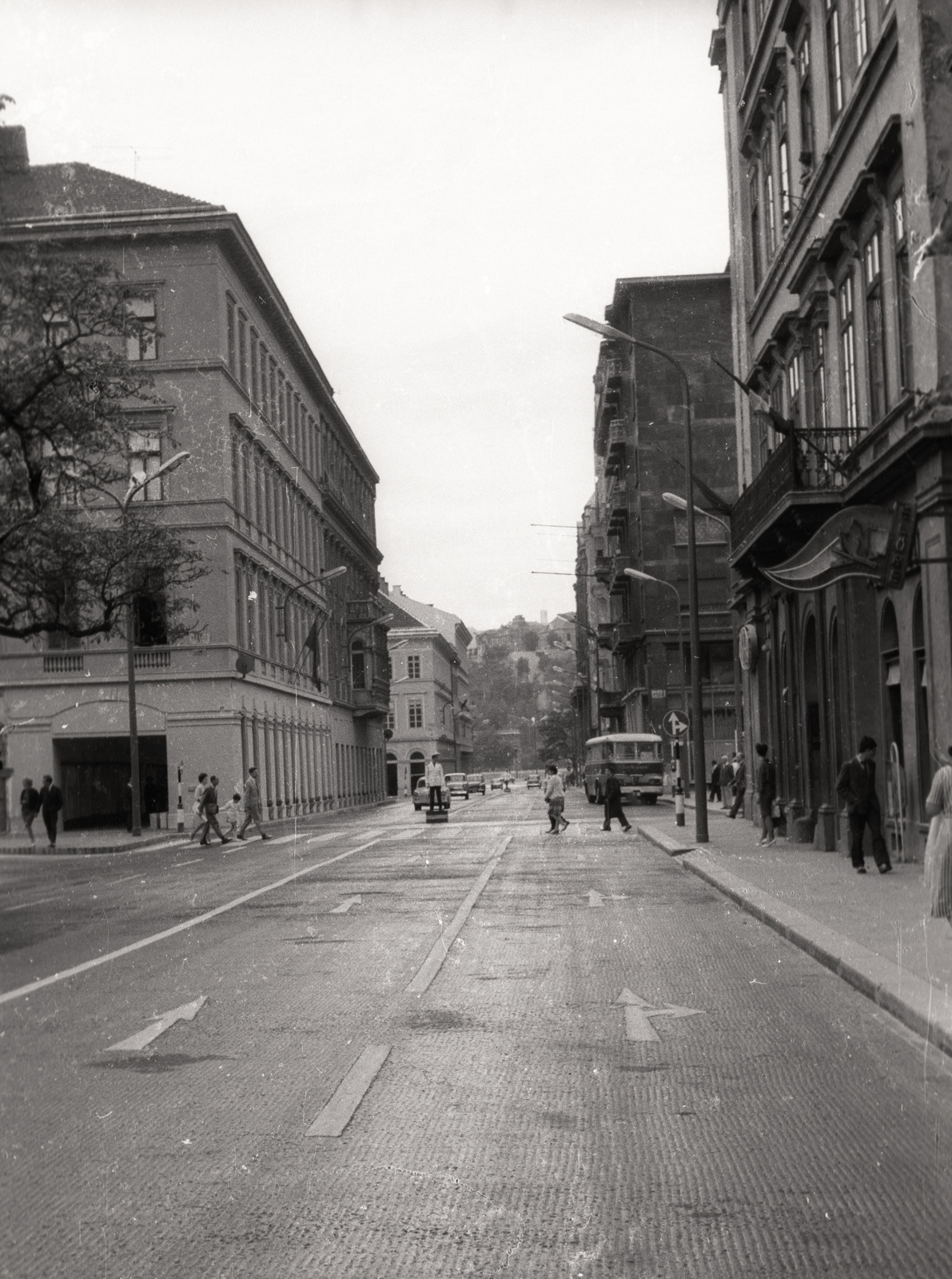 Magyarország, Budapest V., József Attila utca az Erzsébet (Engels) tér felől a Duna felé nézve., 1964, Vaskapu utca, autóbusz, utcakép, életkép, rendőr, neon lámpa, cégér, Budapest, úttörőbolt, Fortepan #94491