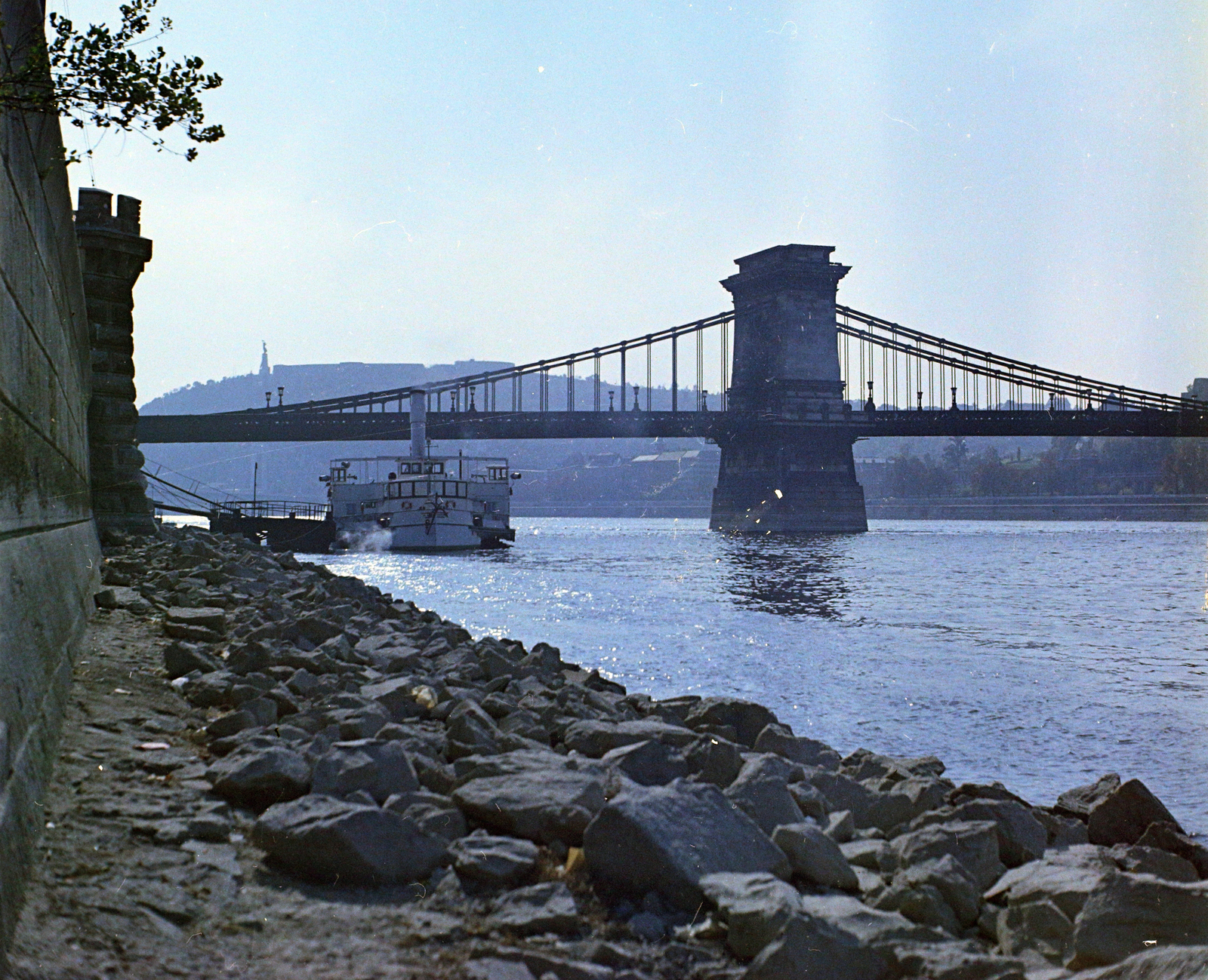 Hungary, Budapest V., Duna-part a Széchenyi István (Roosevelt) térnél, szemben a Széchenyi Lánchíd, háttérben a Gellért-hegy. Előtérben a Kőrös oldalkerekes gőzhajó., 1970, UVATERV, ship, colorful, steamboat, Budapest, suspension bridge, Duna-bridge, William Tierney Clark-design, Fortepan #94848